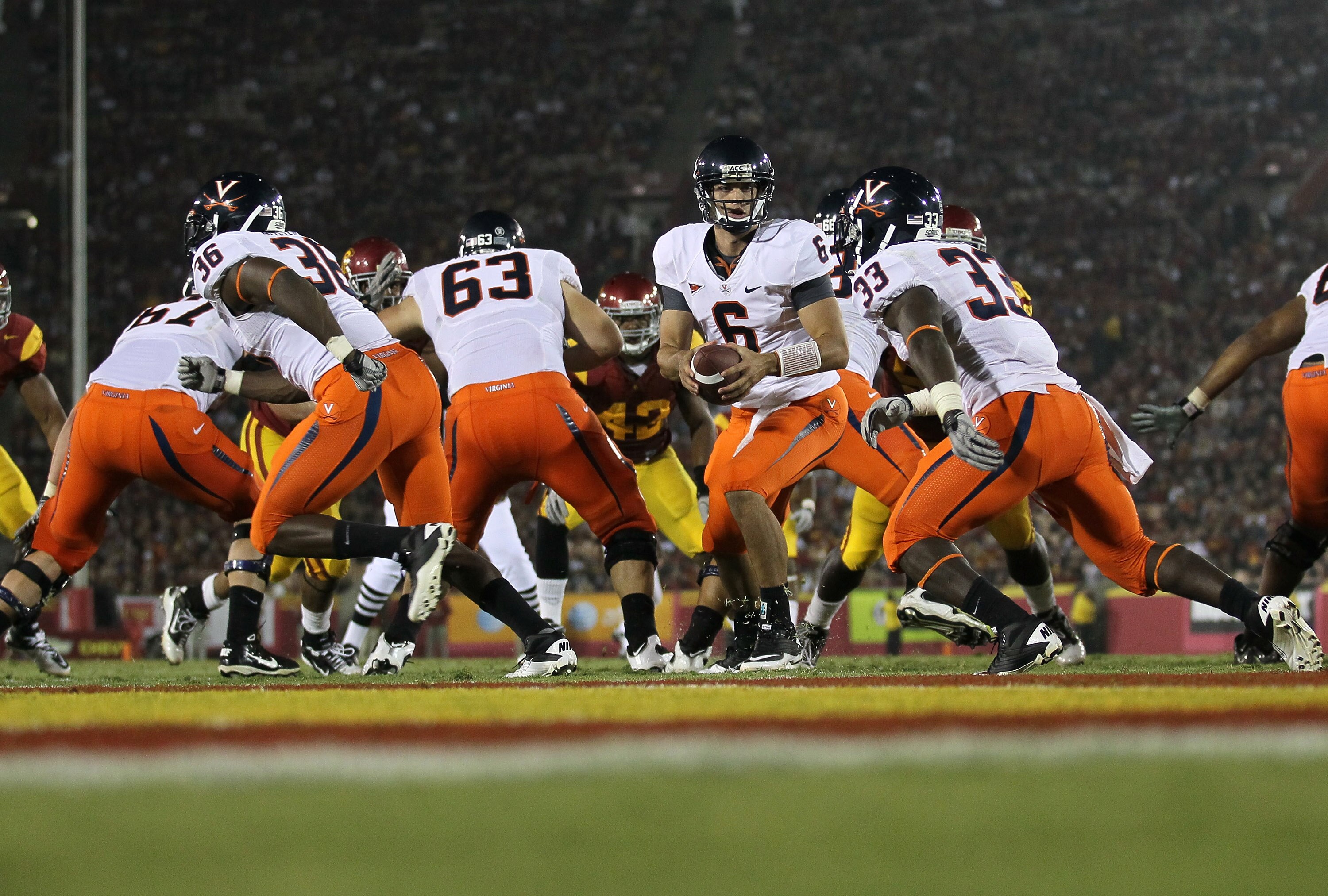 LOS ANGELES, CA - SEPTEMBER 11:  Quarterback Marc Verica #6 of the Virginia Cavalier hands off to running back Perry Jones #33 against the USC Trojans at Los Angeles Memorial Coliseum on September 11, 2010 in Los Angeles, California. USC won 17-14.  (Phot