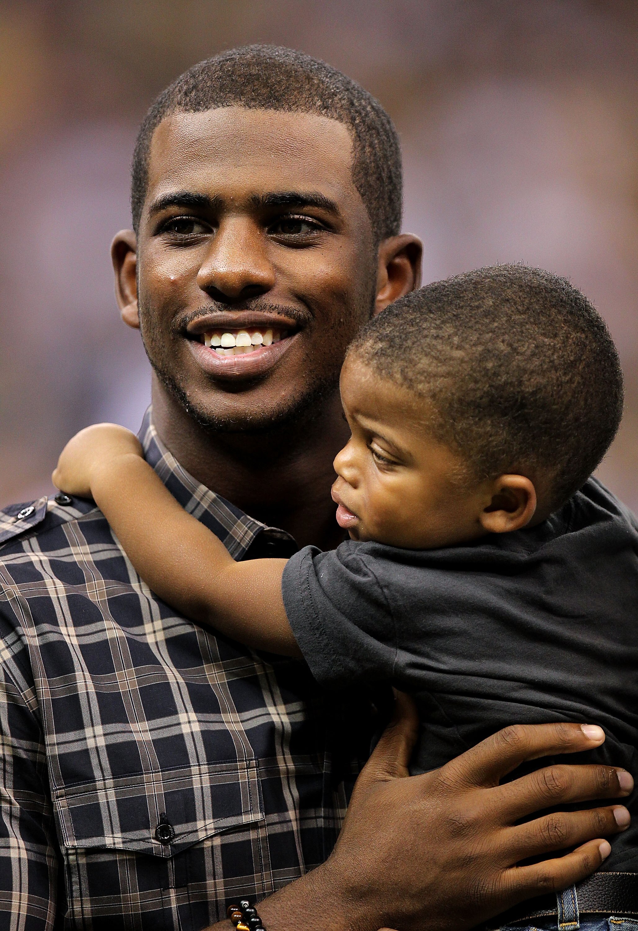 NEW ORLEANS - SEPTEMBER 09:  Chris Paul of the NBA's New Orleans Hornets holds his son Christopher as he stands on the sideline prior to the New Orleans Saints playing against the Minnesota Vikings at Louisiana Superdome on September 9, 2010 in New Orlean