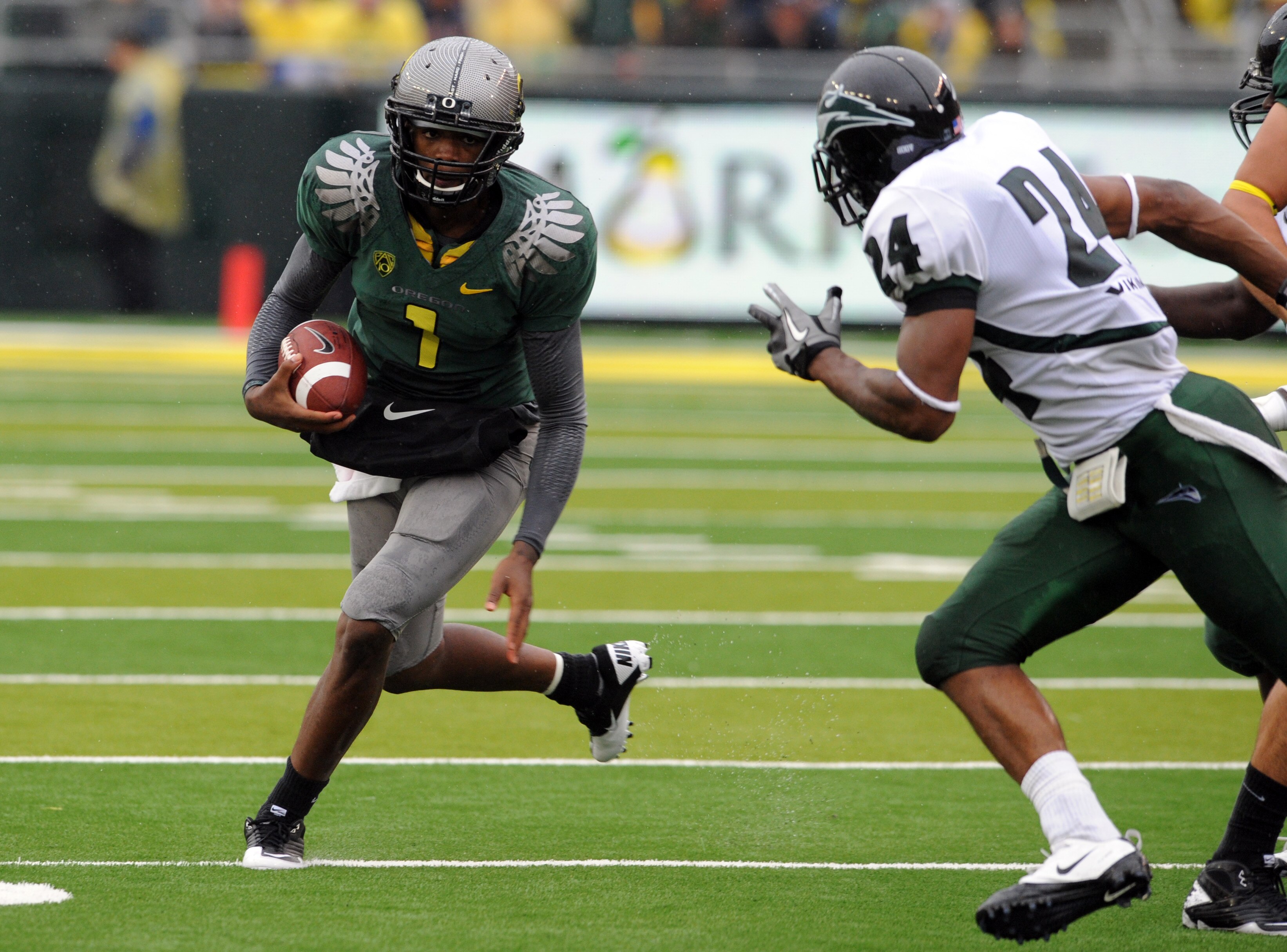 EUGENE, OR - SEPTEMBER 18: Quarterback Darron Thomas #1 of the Oregon Ducks looks for some running room as cornerback Deshawn Shead #24 of the Portland State Vikings closes in during the first quarter of the game against  at Autzen Stadium on September 18