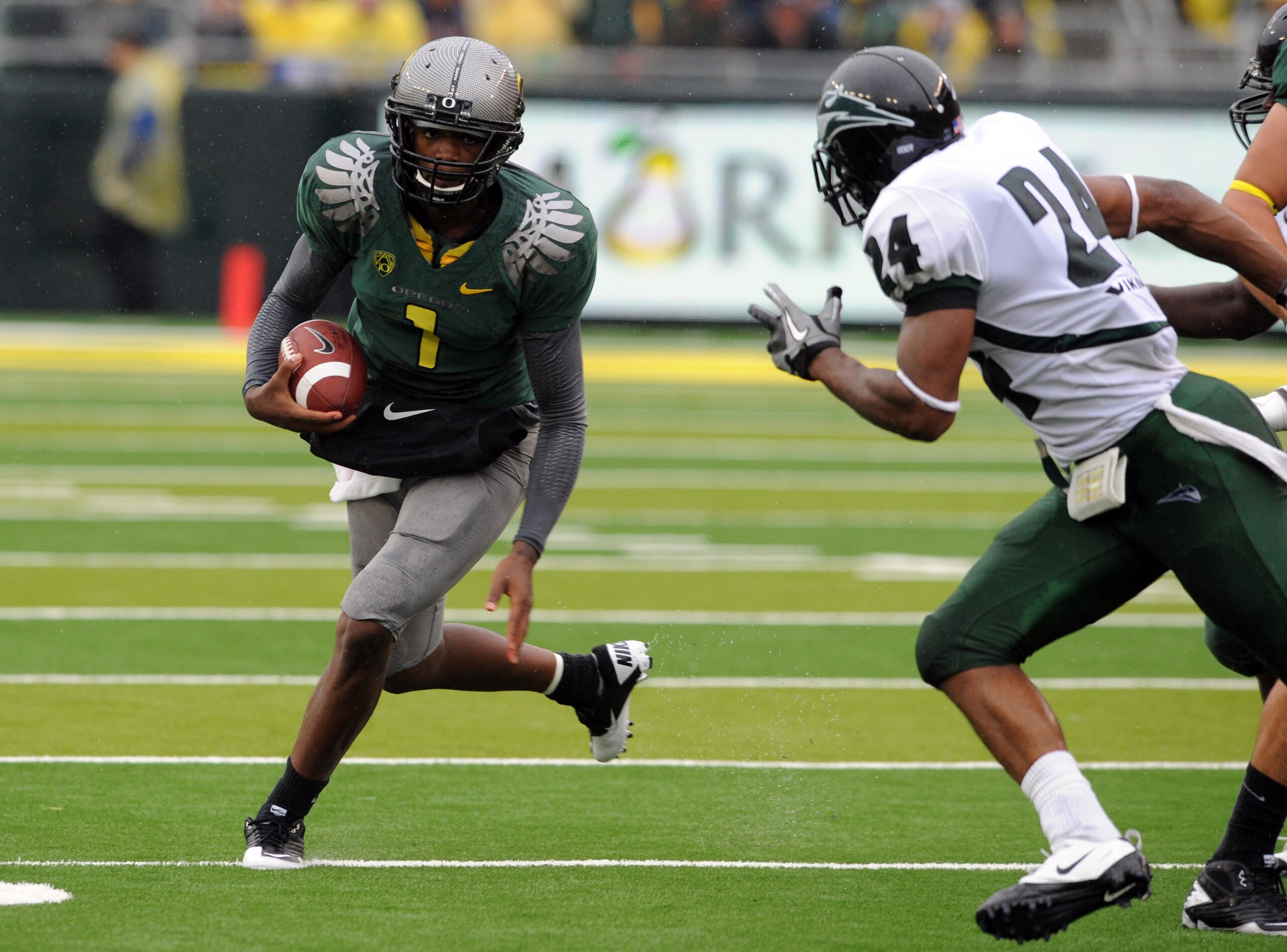 EUGENE, OR - SEPTEMBER 18: Quarterback Darron Thomas #1 of the Oregon Ducks looks for some running room as cornerback Deshawn Shead #24 of the Portland State Vikings closes in during the first quarter of the game against  at Autzen Stadium on September 18