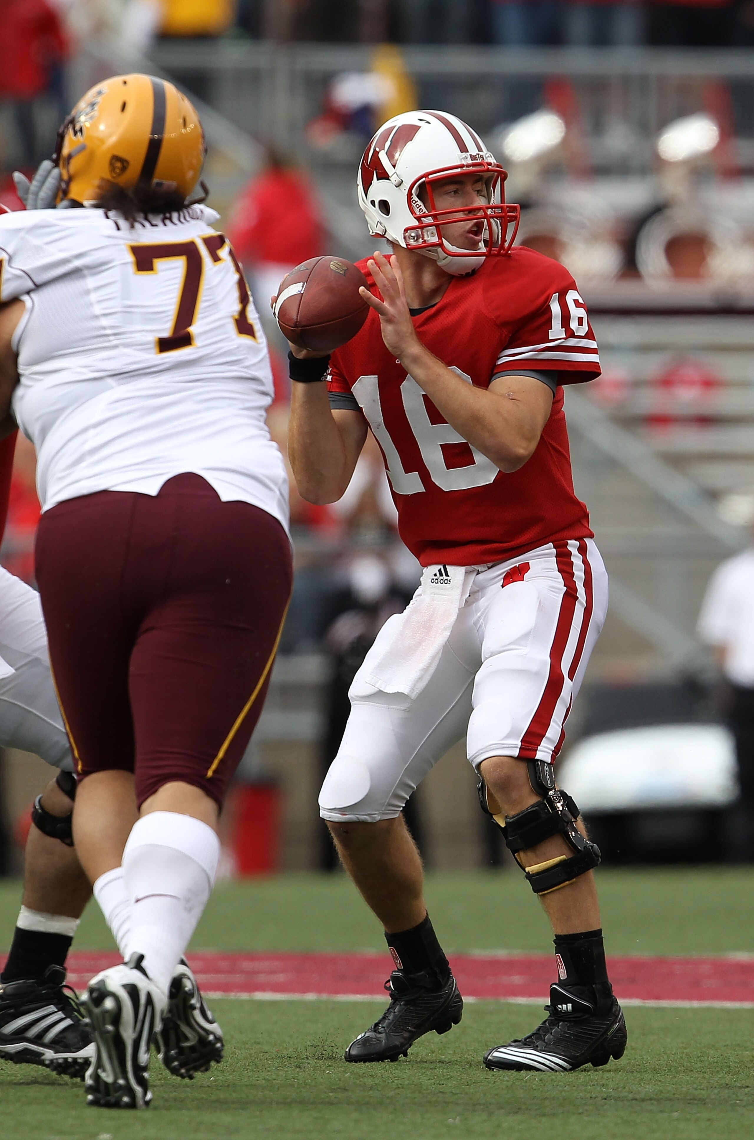 MADISON, WI - SEPTEMBER 18: Scott Tolzien #16 of the Wisconsin Badgers looks for a receiver under pressure from Saia Falahola #77 of the Arizona State Sun Devils at Camp Randall Stadium on September 18, 2010 in Madison, Wisconsin. Wisconsin defeated Arizo