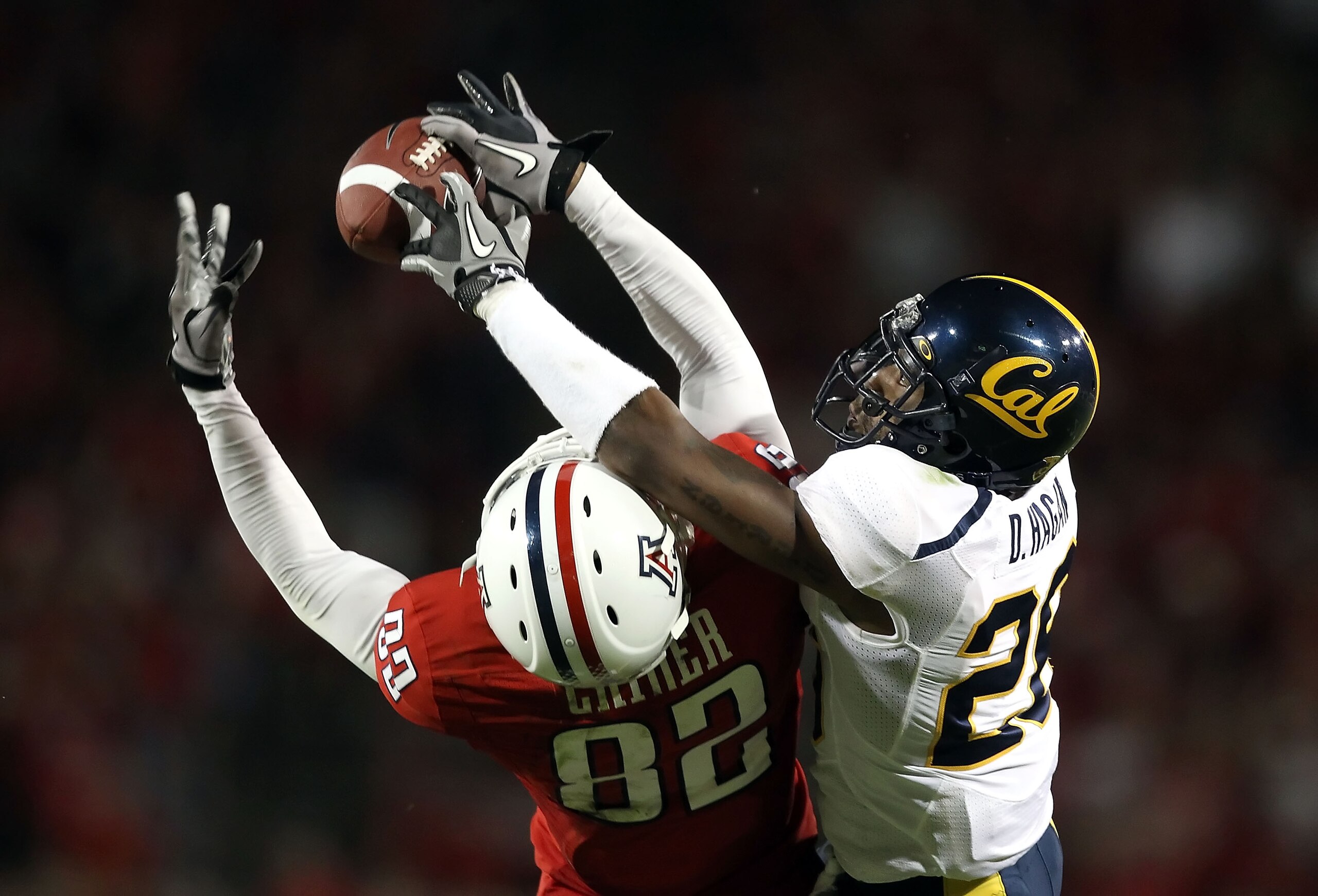 TUCSON, AZ - SEPTEMBER 25:  Wide receiver Juron Criner #82 of the Arizona Wildcats catches a 51 yard reception under pressure from Darian Hagan #26 of the California Golden Bears during the fourth quarter of the college football game at Arizona Stadium on