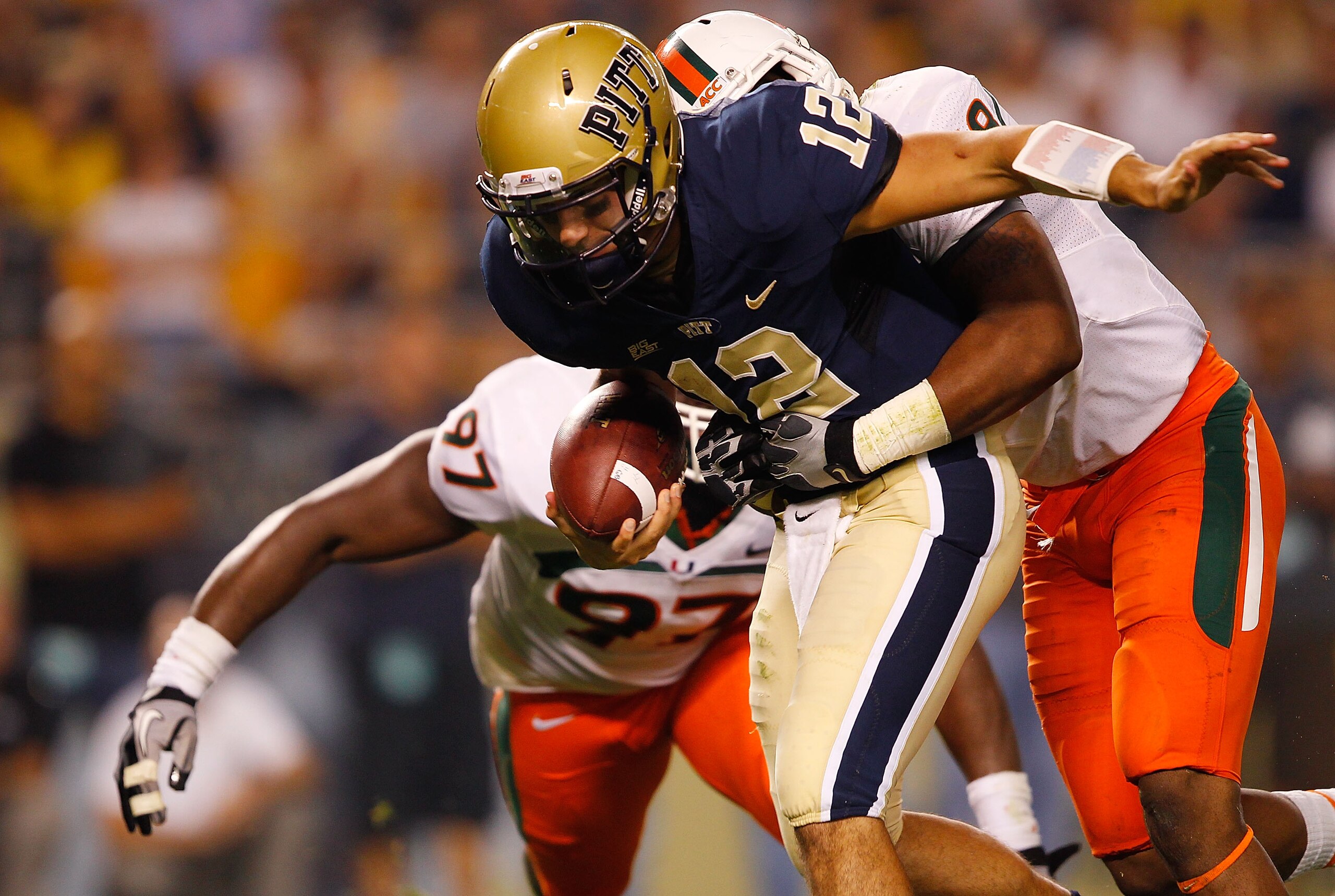PITTSBURGH - SEPTEMBER 23:  Tino Sunseri #12 of the Pittsburgh Panthers is sacked by Andrew Smith #48 of the Miami Hurricanes on September 23, 2010 at Heinz Field in Pittsburgh, Pennsylvania.  (Photo by Jared Wickerham/Getty Images)