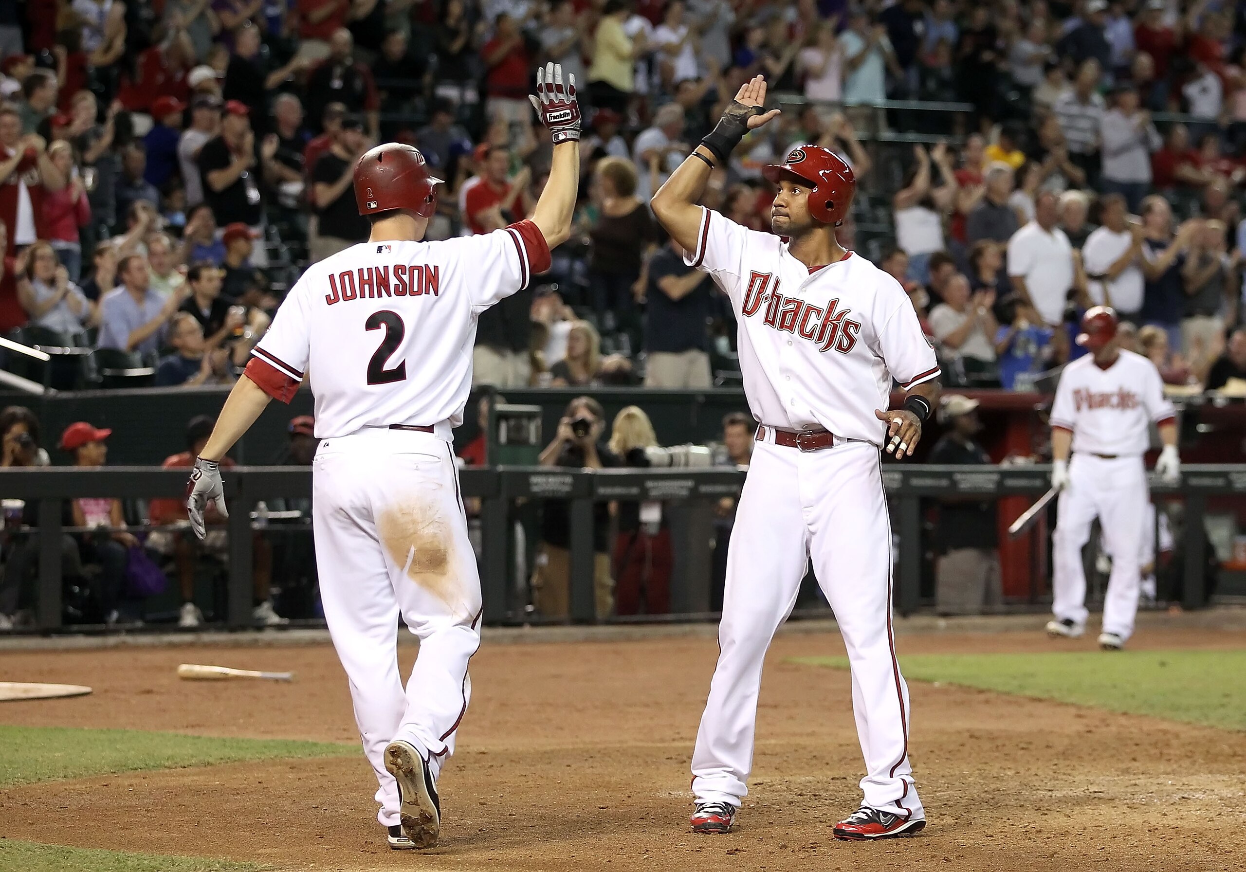 PHOENIX - SEPTEMBER 24:  Chris Young #24 of the Arizona Diamondbacks is congratulated by teammate Kelly Johnson #2 after Young scored a ninth inning run against the Los Angeles Dodgers during the Major League Baseball game at Chase Field on September 24,