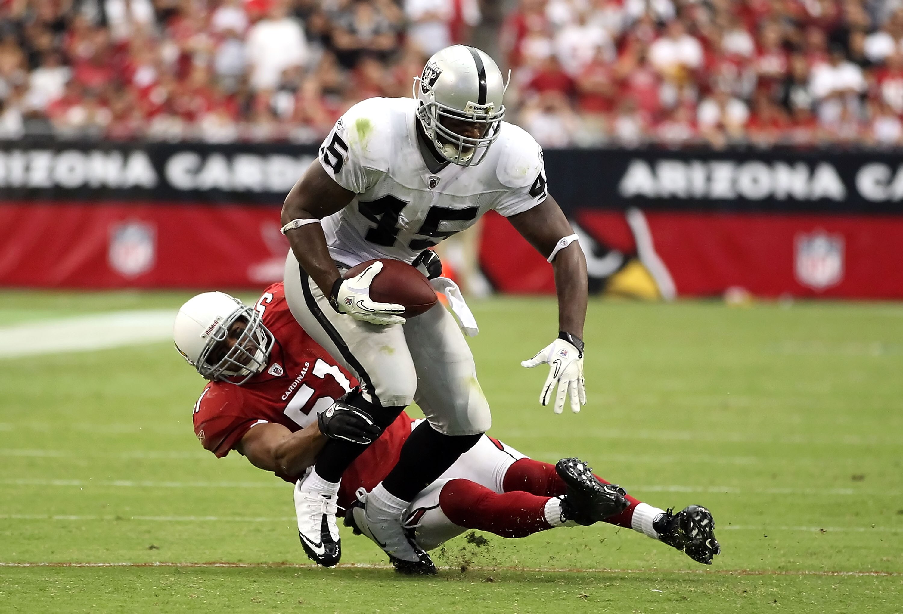 GLENDALE, AZ - SEPTEMBER 26: Runningback Marcel Reece #45 of the Oakland Raiders is tackled by Paris Lenon #51 of the Arizona Cardinals after a reception during the NFL game at the University of Phoenix Stadium on September 26, 2010 in Glendale, Arizona. GLENDALE, AZ - SEPTEMBER 26: Runningback Marcel Reece #45 of the Oakland Raiders is tackled by Paris Lenon #51 of the Arizona Cardinals after a reception during the NFL game at the University of Phoenix Stadium on September 26, 2010 in Glendale, Arizona.