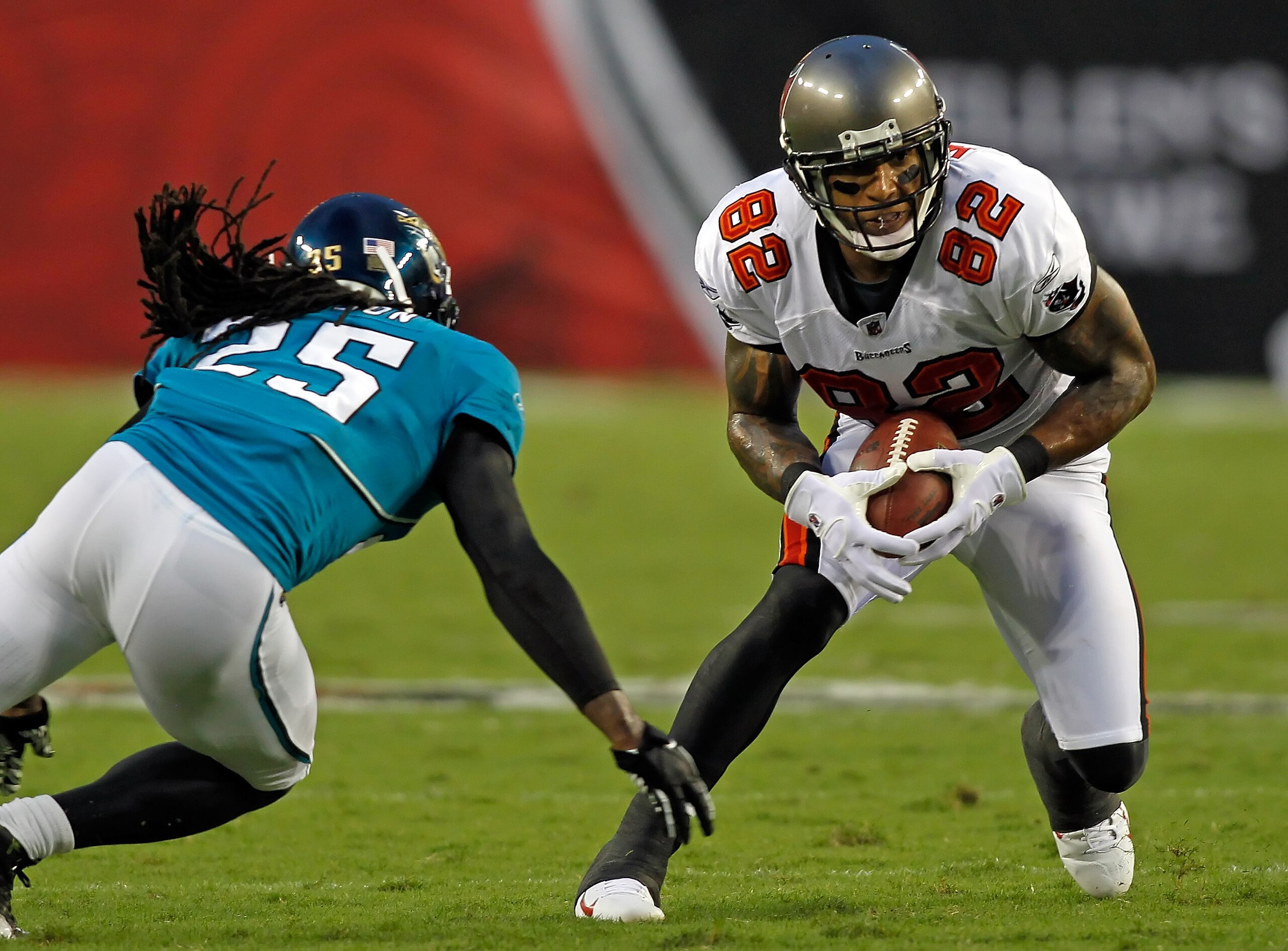 TAMPA, FL - AUGUST 28:  Tight end Kellen Winslow #82 of the Tampa Bay Buccaneers puts a move on safety Reggie Nelson #25 of the Jacksonville Jaguars during a preseason game at Raymond James Stadium on August 28, 2010 in Tampa, Florida.  (Photo by J. Meric