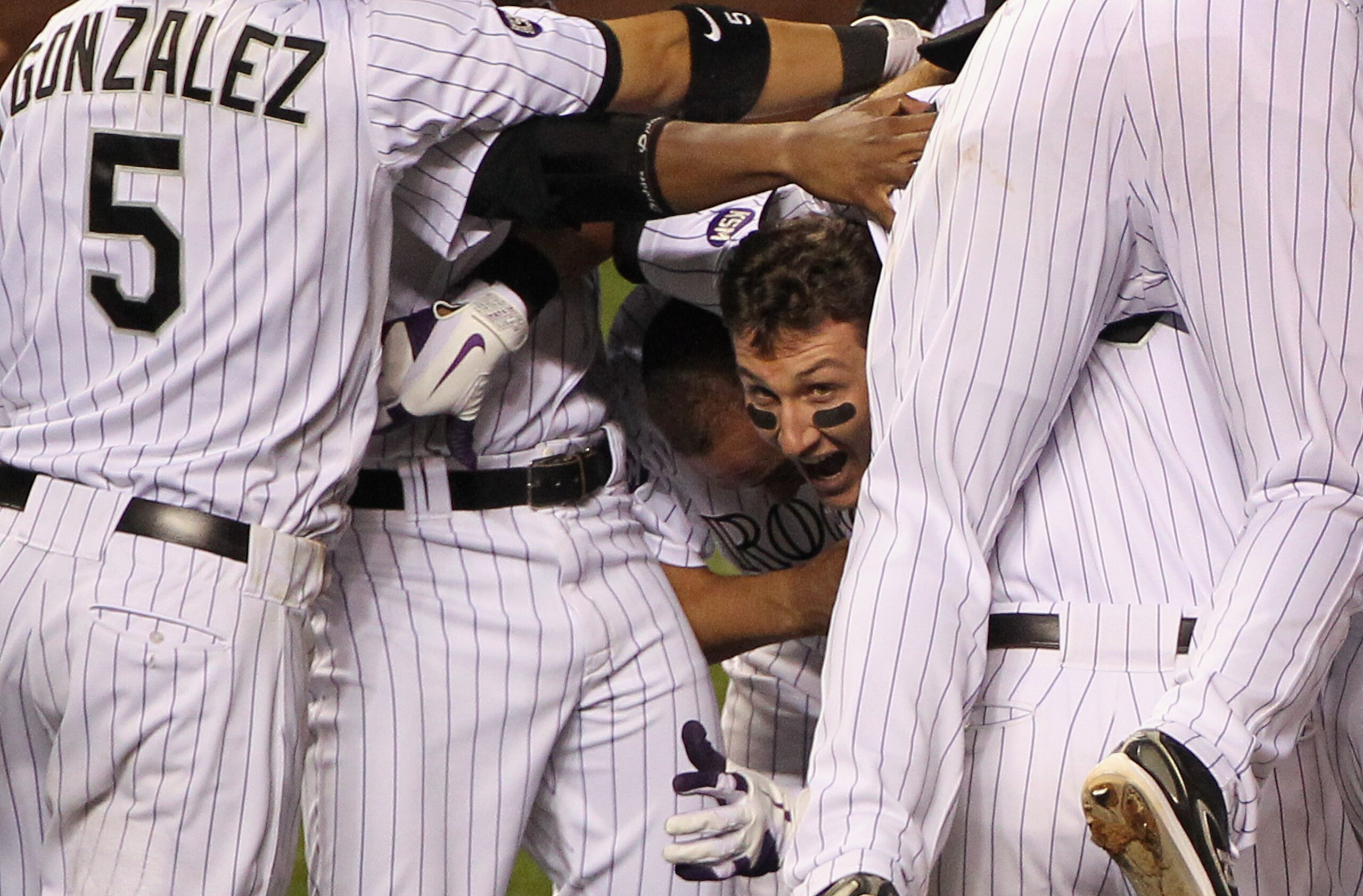 DENVER - SEPTEMBER 25:  Troy Tulowitzki #2 of the Colorado Rockies emerges from the celebration after he hit the game RBI double to score Carlos Gonzalez #5 against the San Francisco Giants in the 10th inning at Coors Field on September 25, 2010 in Denver