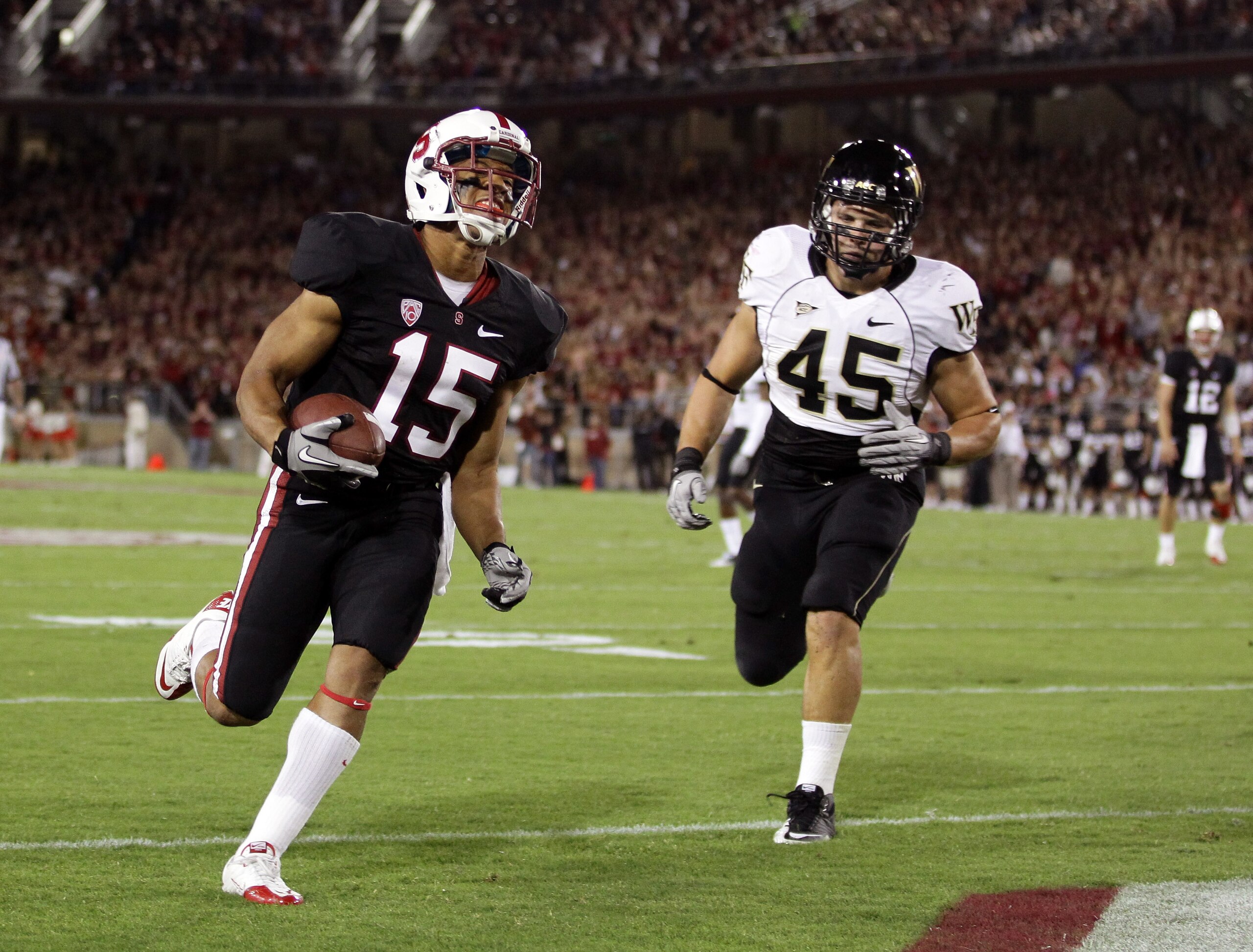 PALO ALTO, CA - SEPTEMBER 18:  Usua Amanam #15 of the Stanford Cardinal gets past Riley Haynes #45 of the Wake Forest Demon Deacons to score a touchdown at Stanford Stadium on September 18, 2010 in Palo Alto, California.  (Photo by Ezra Shaw/Getty Images)