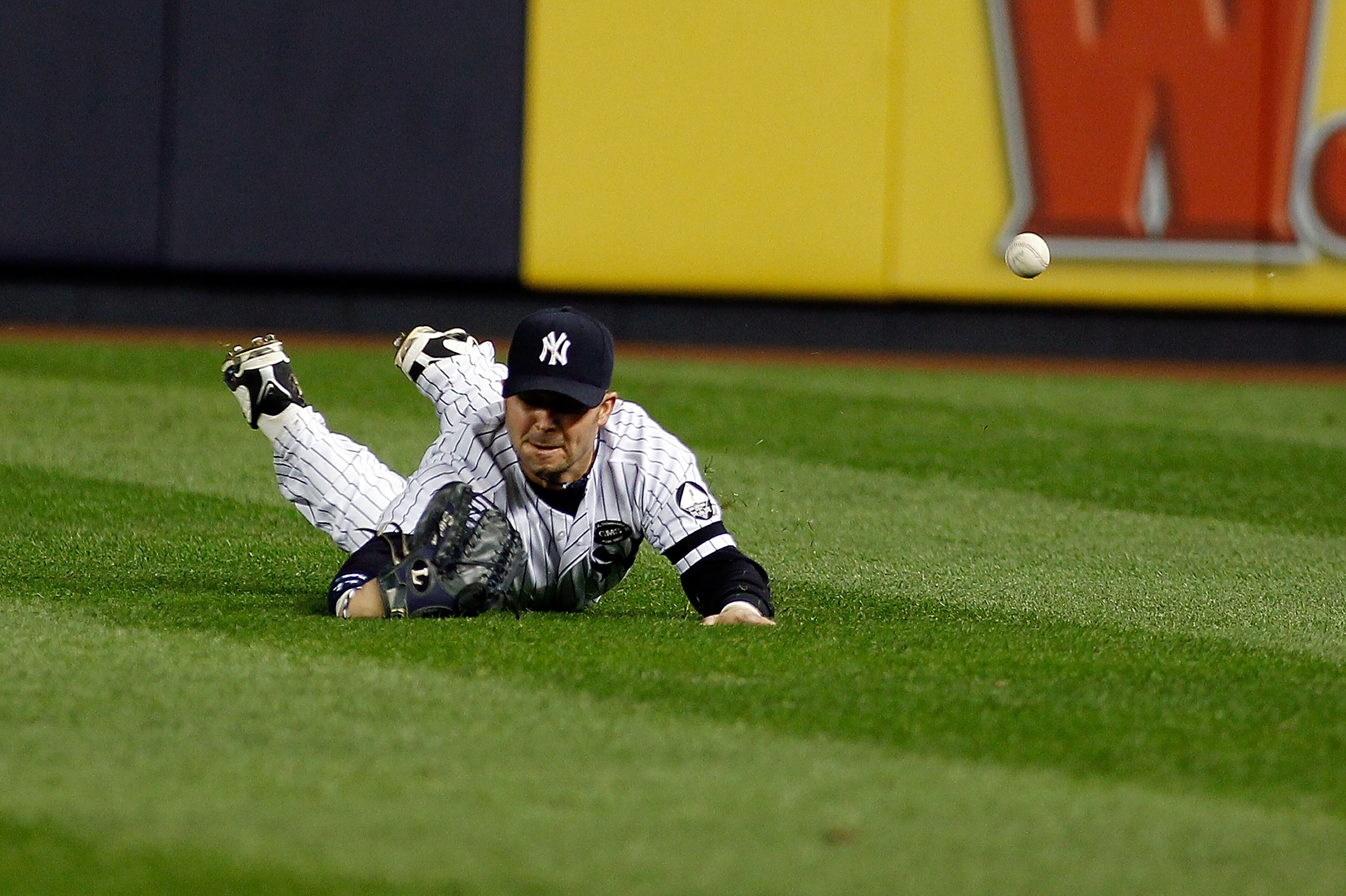 NEW YORK - SEPTEMBER 26:  Nick Swisher #33 of the New York Yankees misplays the ball on Bill Hall #22 of the Boston Red Sox (not shown) hit in the third-inning on September 26, 2010 at Yankee Stadium in the Bronx borough of New York City.  (Photo by Mike