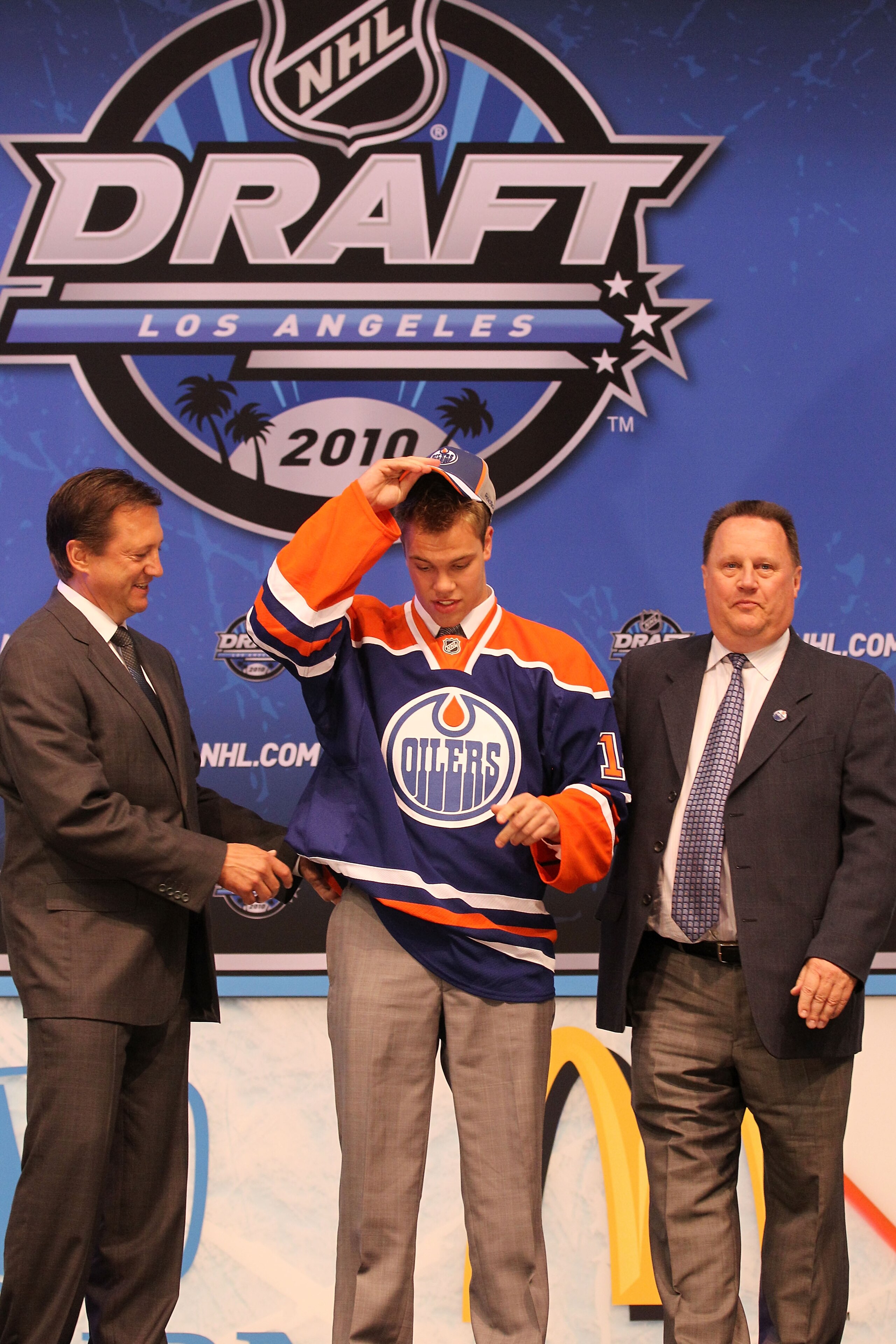 LOS ANGELES, CA - JUNE 25:  Taylor Hall, drafted #1 overall by the Edmonton Oilers, puts on his jersey during the 2010 NHL Entry Draft at Staples Center on June 25, 2010 in Los Angeles, California.  (Photo by Bruce Bennett/Getty Images)
