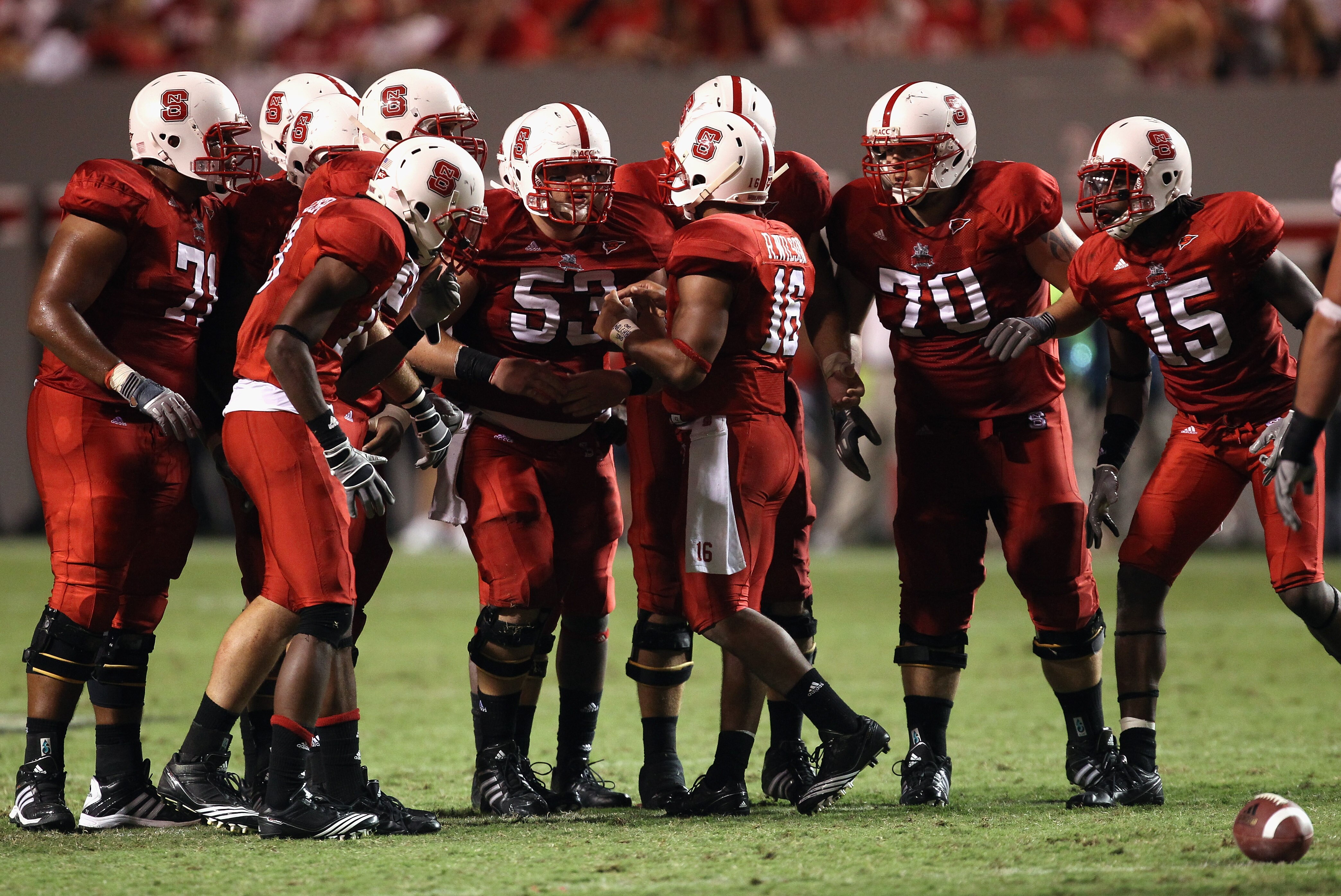 RALEIGH, NC - SEPTEMBER 16:  Russell Wilson #16 of the North Carolina State Wolfpack talks to his team in the huddle against the Cincinnati Bearcats during their game at Carter-Finley Stadium on September 16, 2010 in Raleigh, North Carolina.  (Photo by St