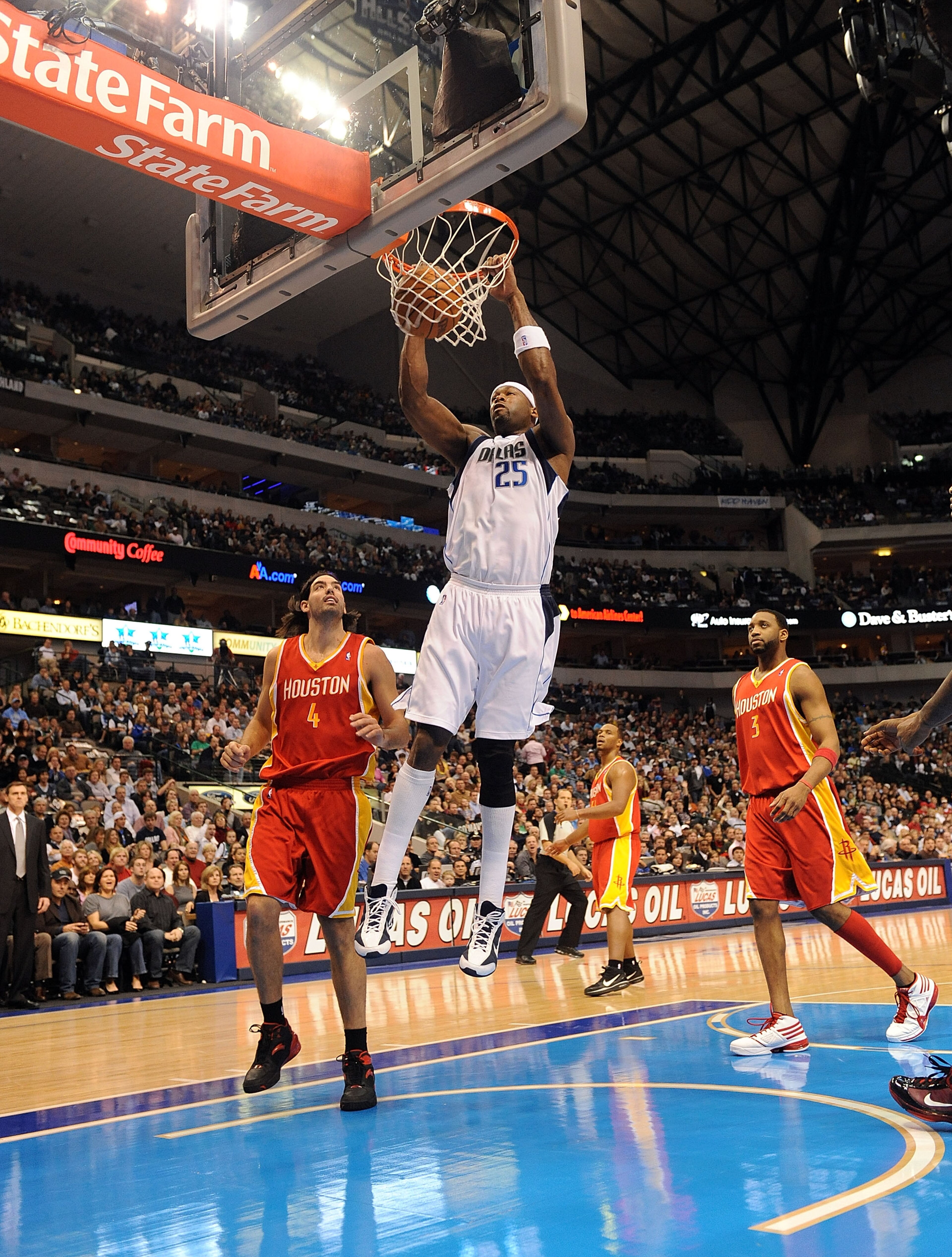 DALLAS - DECEMBER 18:  Center Erick Dampier #25 of the Dallas Mavericks gets the slam dunk against Luis Scola #4 of the Houston Rockets on December 18, 2009 at American Airlines Center in Dallas, Texas.  NOTE TO USER: User expressly acknowledges and agree
