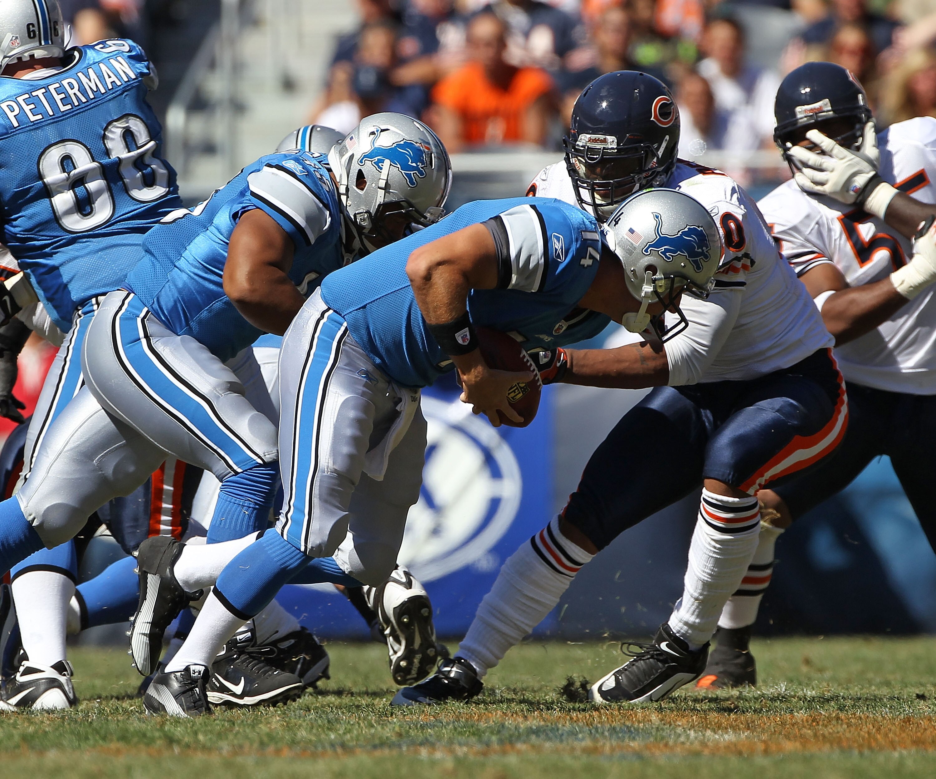 CHICAGO - SEPTEMBER 12: Shaun Hill #14 of the Detroit Lions tries to run after recovering his own fumbled snap as Julius Peppers #90 of the Chicago Bears attempts the tackle during the NFL season opening game at Soldier Field on September 12, 2010 in Chic