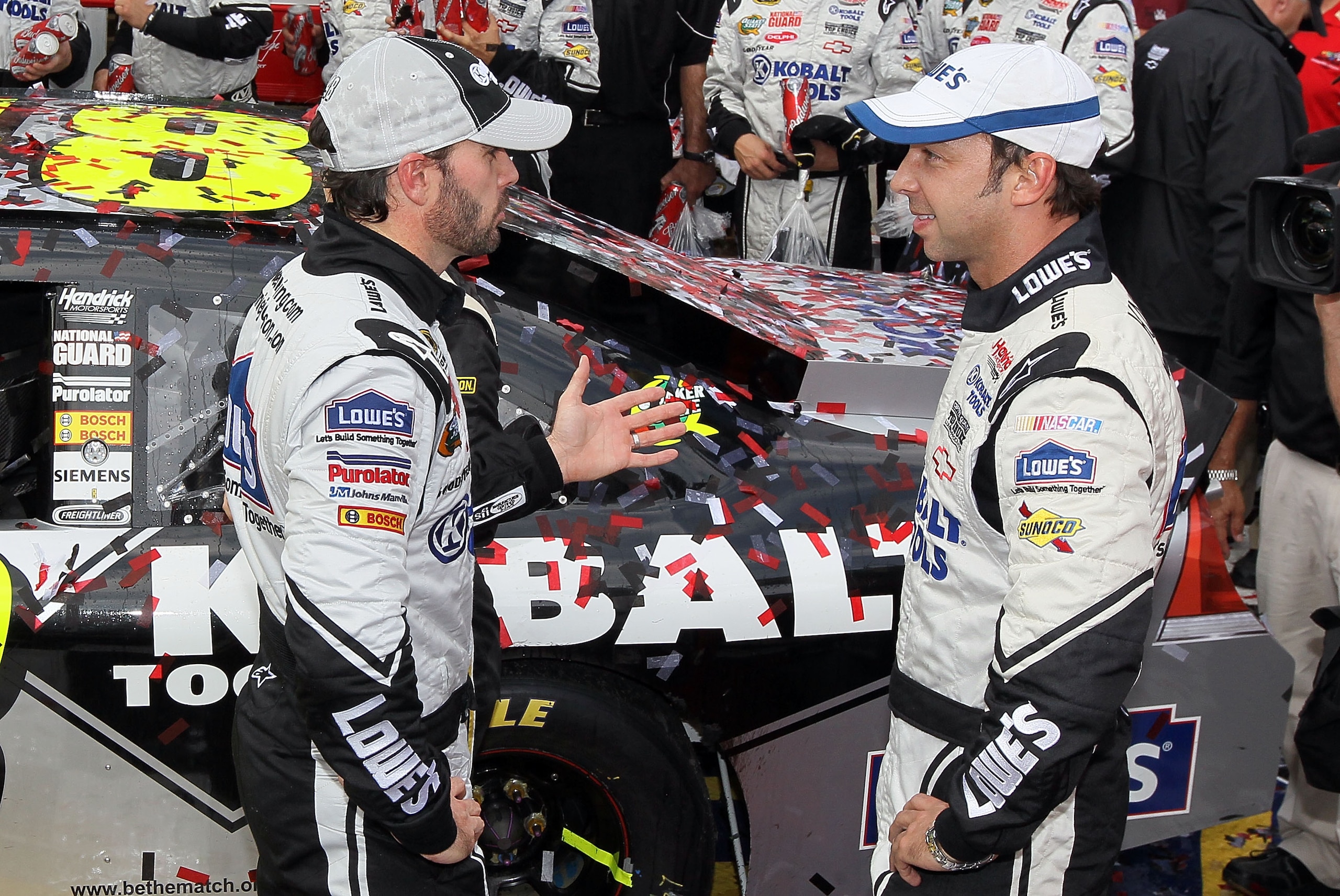 DOVER, DE - SEPTEMBER 26:  Jimmie Johnson (L), driver of the #48 Lowe's Chevrolet, and crew chief Chad Knaus talk in Victory Lane after winning the NASCAR Sprint Cup Series AAA 400 at Dover International Speedway on September 26, 2010 in Dover, Delaware.