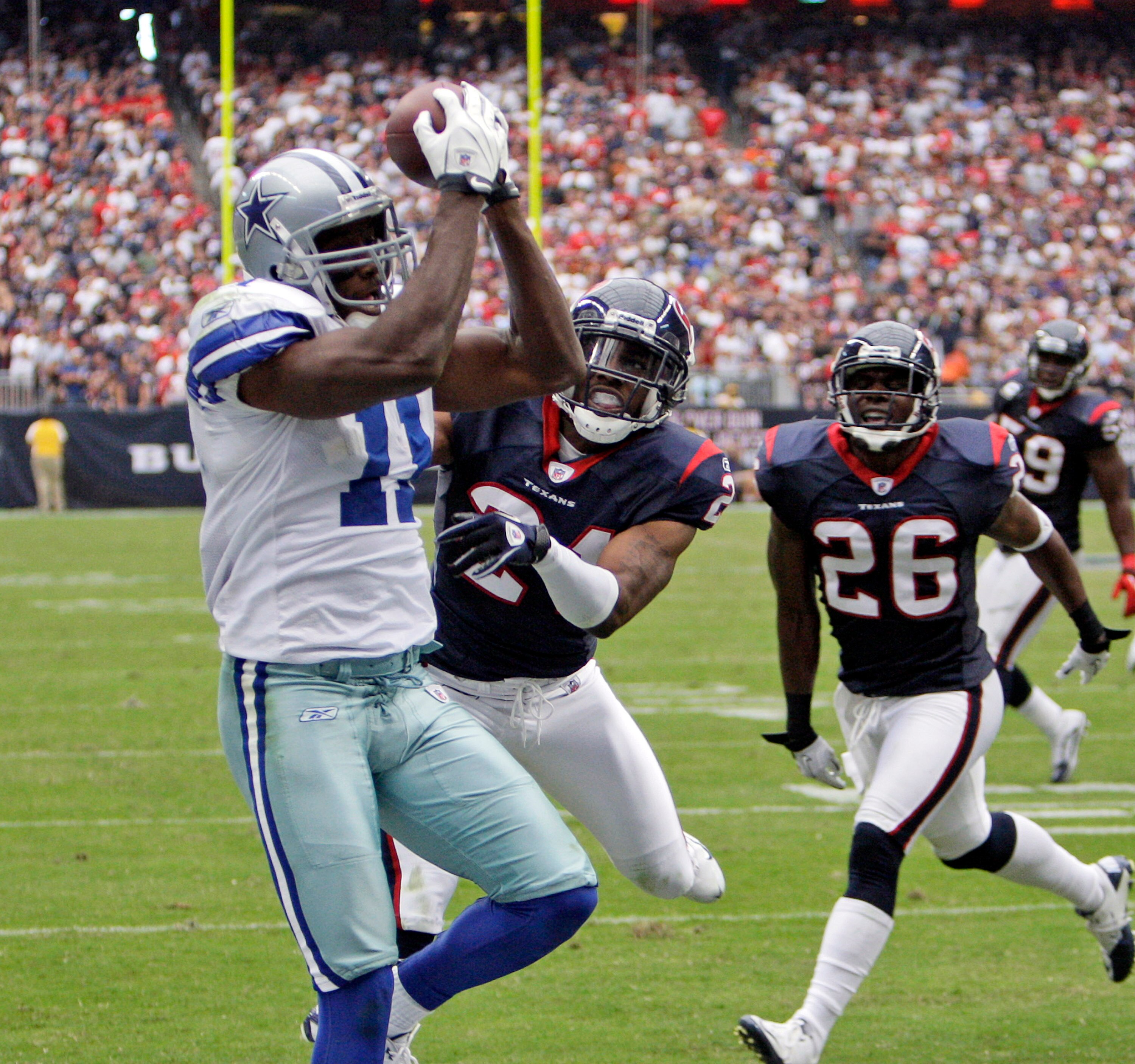 HOUSTON - SEPTEMBER 26:  Wide receiver Roy Williams #11 of the Dallas Cowboys catches a pass for a touchdown as he beats cornerbacks Brice McCain #21 and Eugene Wilson #26 of the Houston Texans in the third quarter at Reliant Stadium on September 26, 2010