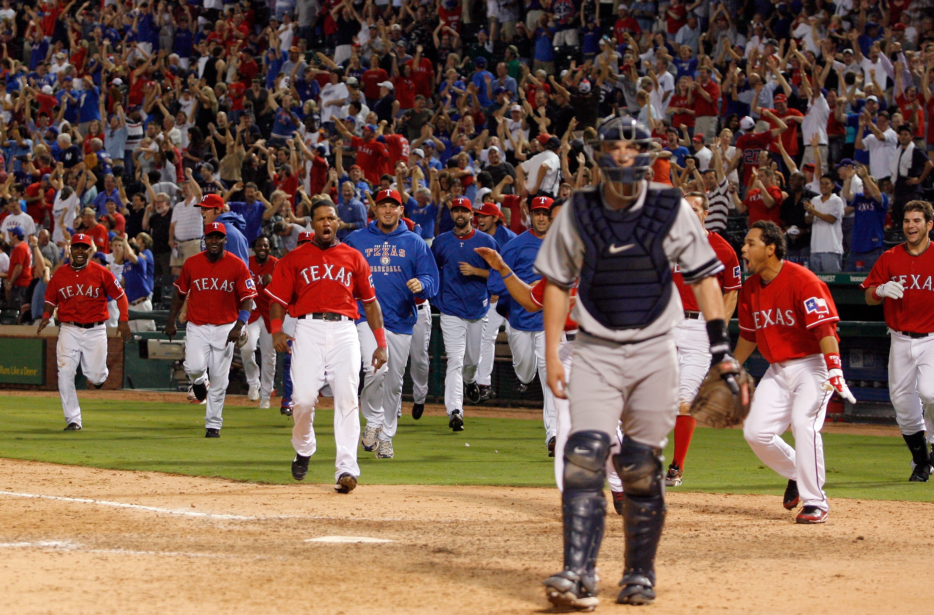 ARLINGTON, TX - SEPTEMBER 10: The Texas Rangers celebrate at home plate after Nelson Cruz #17 hit the game-winning home run in the bottom of the 13th inning against the New York Yankees on September 10, 2010 at Rangers Ballpark in Arlington, Texas. (Pho ARLINGTON, TX - SEPTEMBER 10: The Texas Rangers celebrate at home plate after Nelson Cruz #17 hit the game-winning home run in the bottom of the 13th inning against the New York Yankees on September 10, 2010 at Rangers Ballpark in Arlington, Texas. (Pho