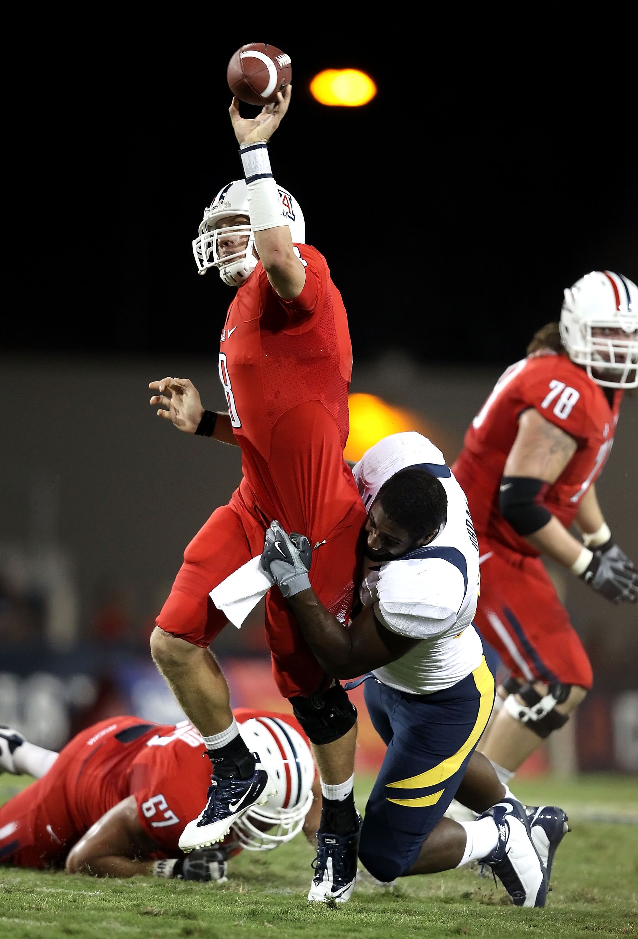TUCSON, AZ - SEPTEMBER 25:  Quarterback Nick Foles #8 of the Arizona Wildcats is pressured into throwing an incomplete pass by Cameron Jordan #97 of the California Bears during the first quarter of the college football game at Arizona Stadium on September