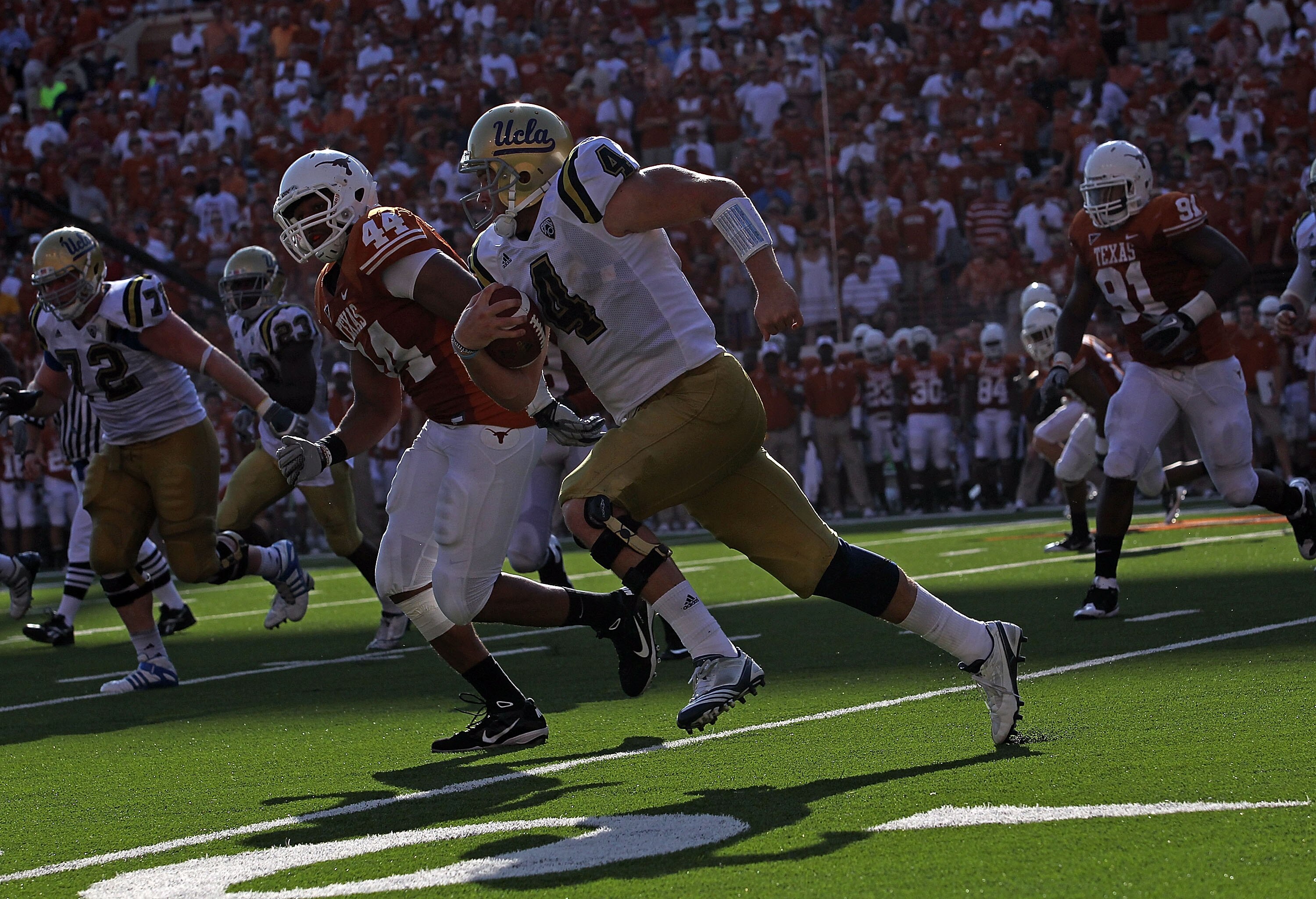 AUSTIN, TX - SEPTEMBER 25:  Quarterback Kevin Prince #4 of the UCLA Bruins runs the ball past Jackson Jeffcoat #44 of the Texas Longhorns at Darrell K Royal-Texas Memorial Stadium on September 25, 2010 in Austin, Texas.  (Photo by Ronald Martinez/Getty Im