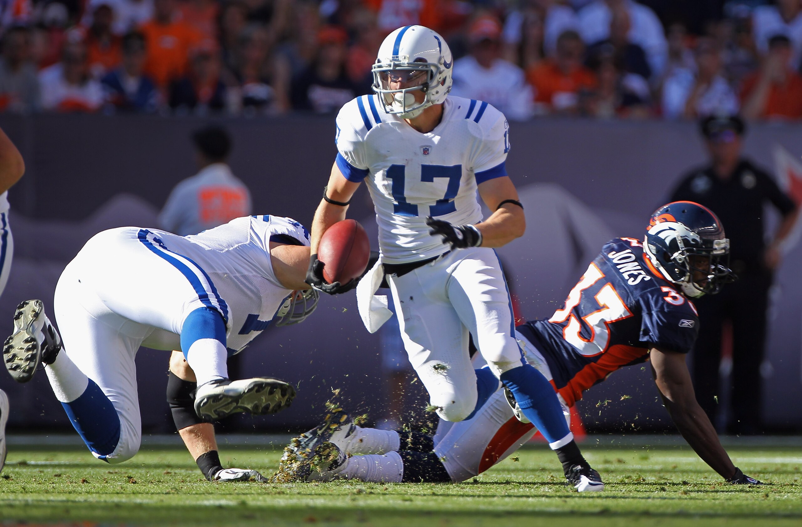 DENVER - SEPTEMBER 26:  Wide receiver Austin Collie #17 of the Indianapolis Colts makes a reception and picks up a first down as as Ryan Diem #71 of the Colts blocks Nate Jones #33 of the Denver Broncos at INVESCO Field at Mile High on September 26, 2010 
