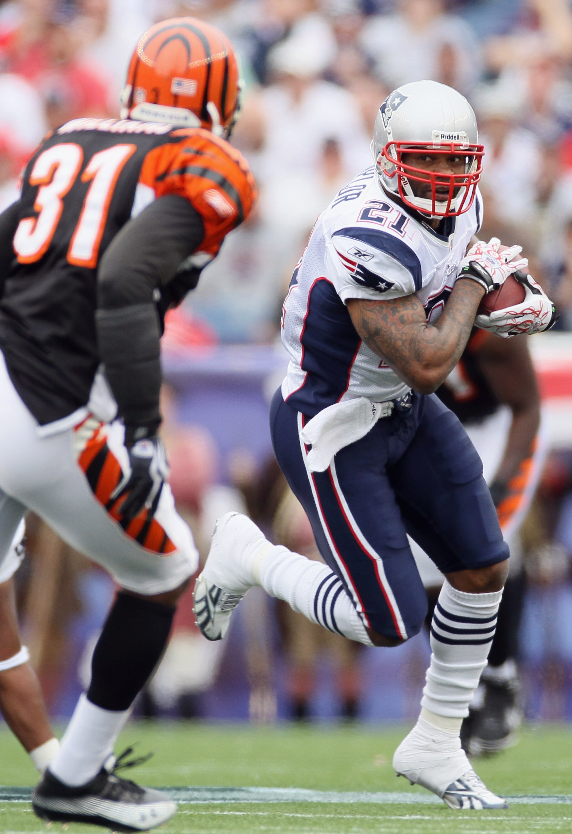 FOXBORO, MA - SEPTEMBER 12:  Fred Taylor #21 of the New England Patriots carries the ball as Roy Williams #31 defends during the NFL season opener on September 12, 2010 at Gillette Stadium in Foxboro, Massachusetts. The Patriots defeated the Bengals 38-24