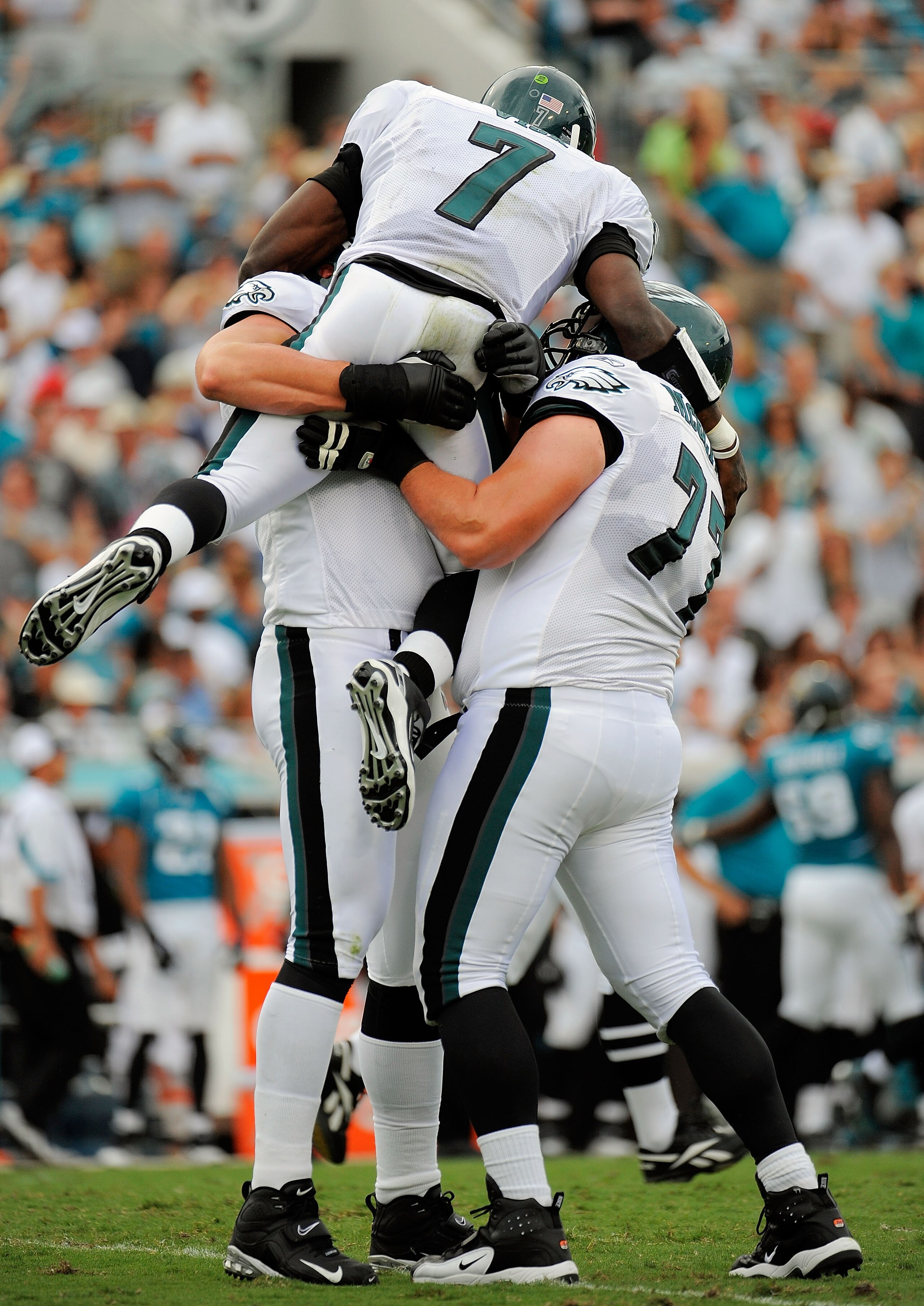 JACKSONVILLE, FL - SEPTEMBER 26:  Quarterback Michael Vick #7 of the Philadelphia Eagles celebrates with offensive linemen Todd Herremans #79 and Mike McGlynn #77 after throwing a touchdown pass in the first quarter against the Jacksonville Jaguars at Eve