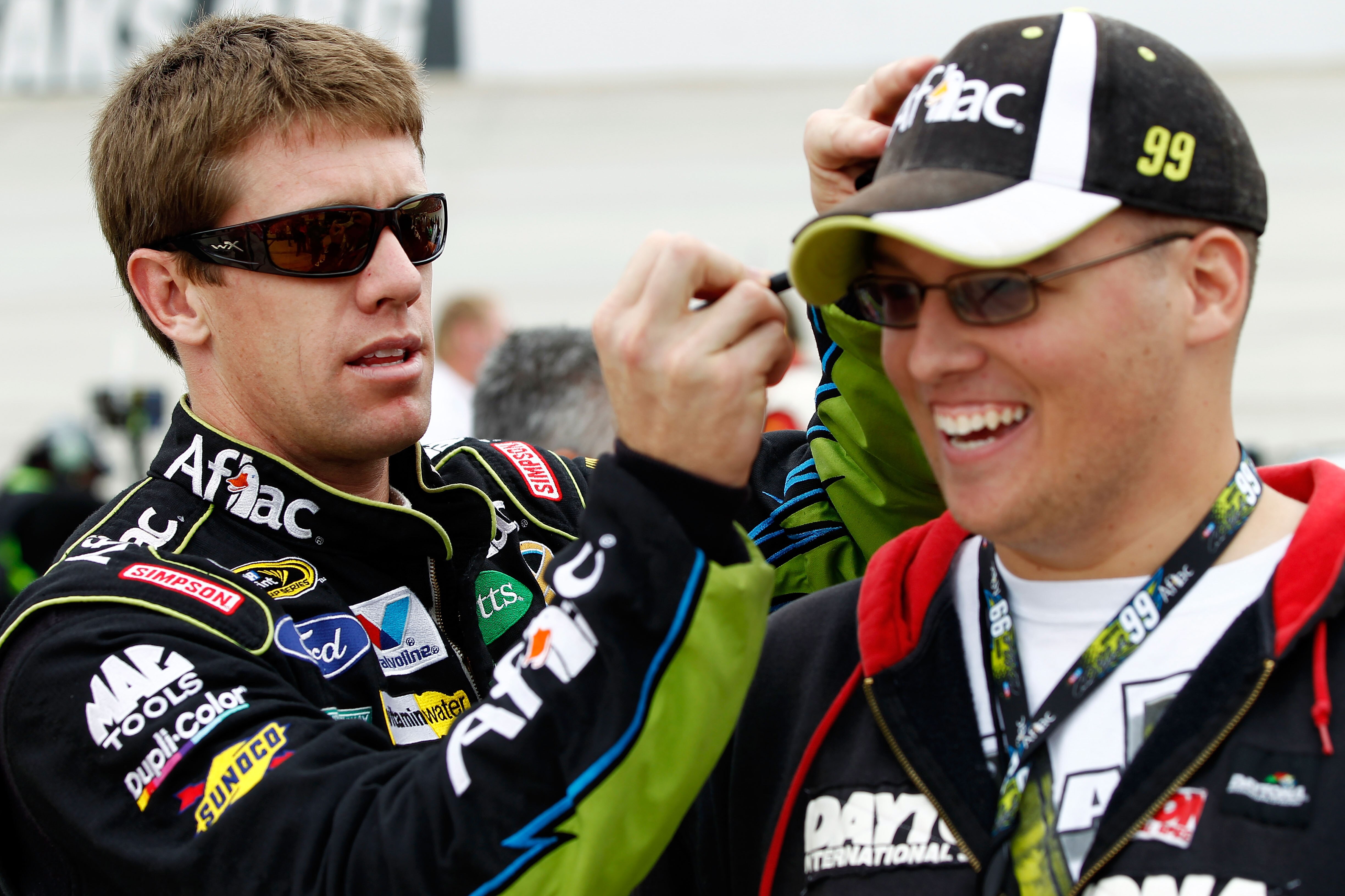 DOVER, DE - SEPTEMBER 26:  Carl Edwards (L), driver of the #99 Aflac Ford, signs a fans hat prior to the NASCAR Sprint Cup Series AAA 400 at Dover International Speedway on September 26, 2010 in Dover, Delaware.  (Photo by Jeff Zelevansky/Getty Images for