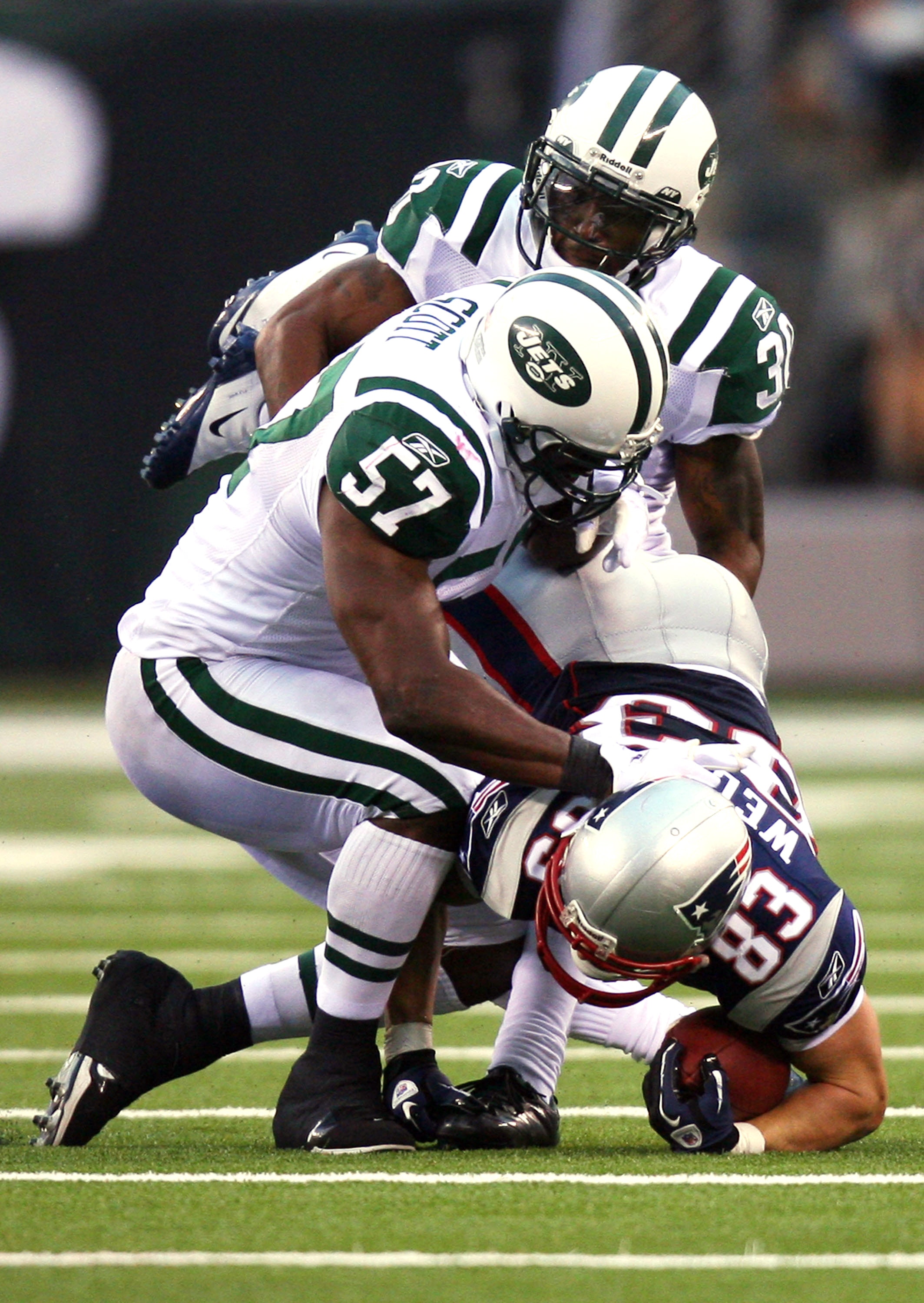 EAST RUTHERFORD, NJ - SEPTEMBER 19:  Wes Welker #83 of the New England Patriots is tackled by Bart Scott #57 of the New York Jets at the New Meadowlands Stadium on September 19, 2010 in East Rutherford, New Jersey. The Jets defeated the Patriots 28 - 14.