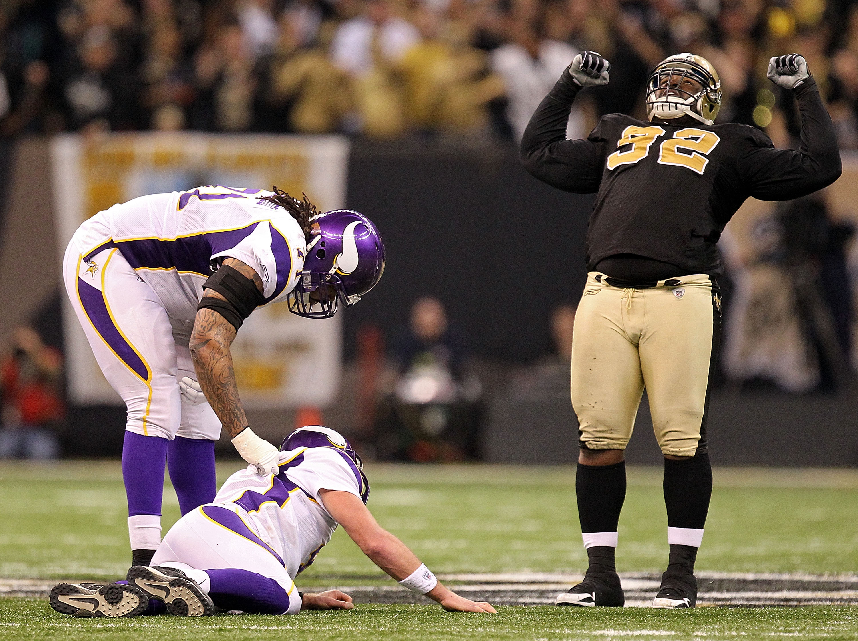 NEW ORLEANS - JANUARY 24:  Phil Loadholt #71 of the Minnesota Vikings checks on teammate Brett Favre #4  after he was hit by Remi Ayodele #92 of the New Orleans Saints during the NFC Championship Game at the Louisiana Superdome on January 24, 2010 in New