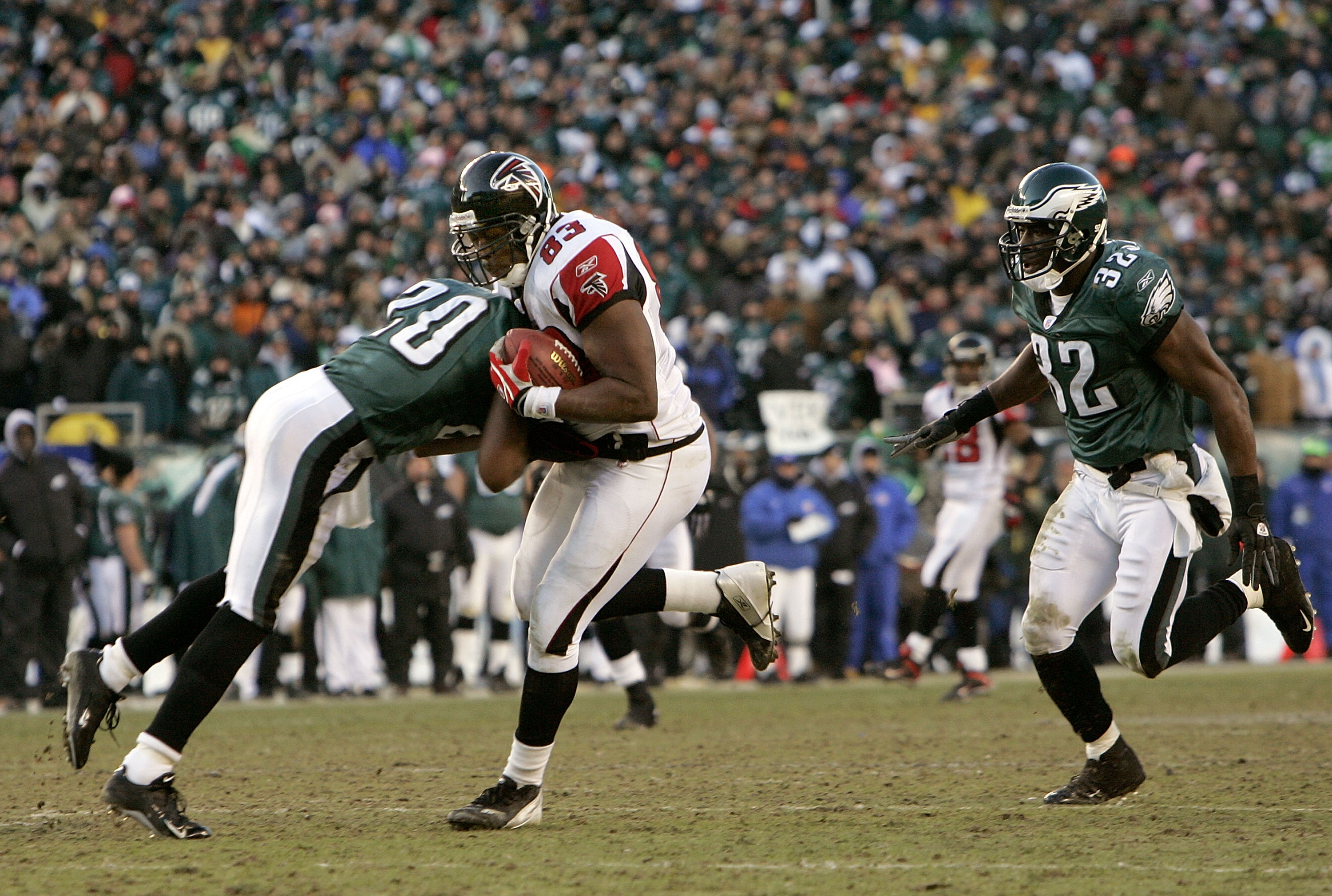 PHILADELPHIA - JANUARY 23:  Tightend Alge Crumpler #83 of the Atlanta Falcons is hit by Brian dawkins #20 of the Philadelphia Eagles in the second quarter during the NFC Championship game at Lincoln Financial Field on January 23, 2005 in Philadelphia, Pen