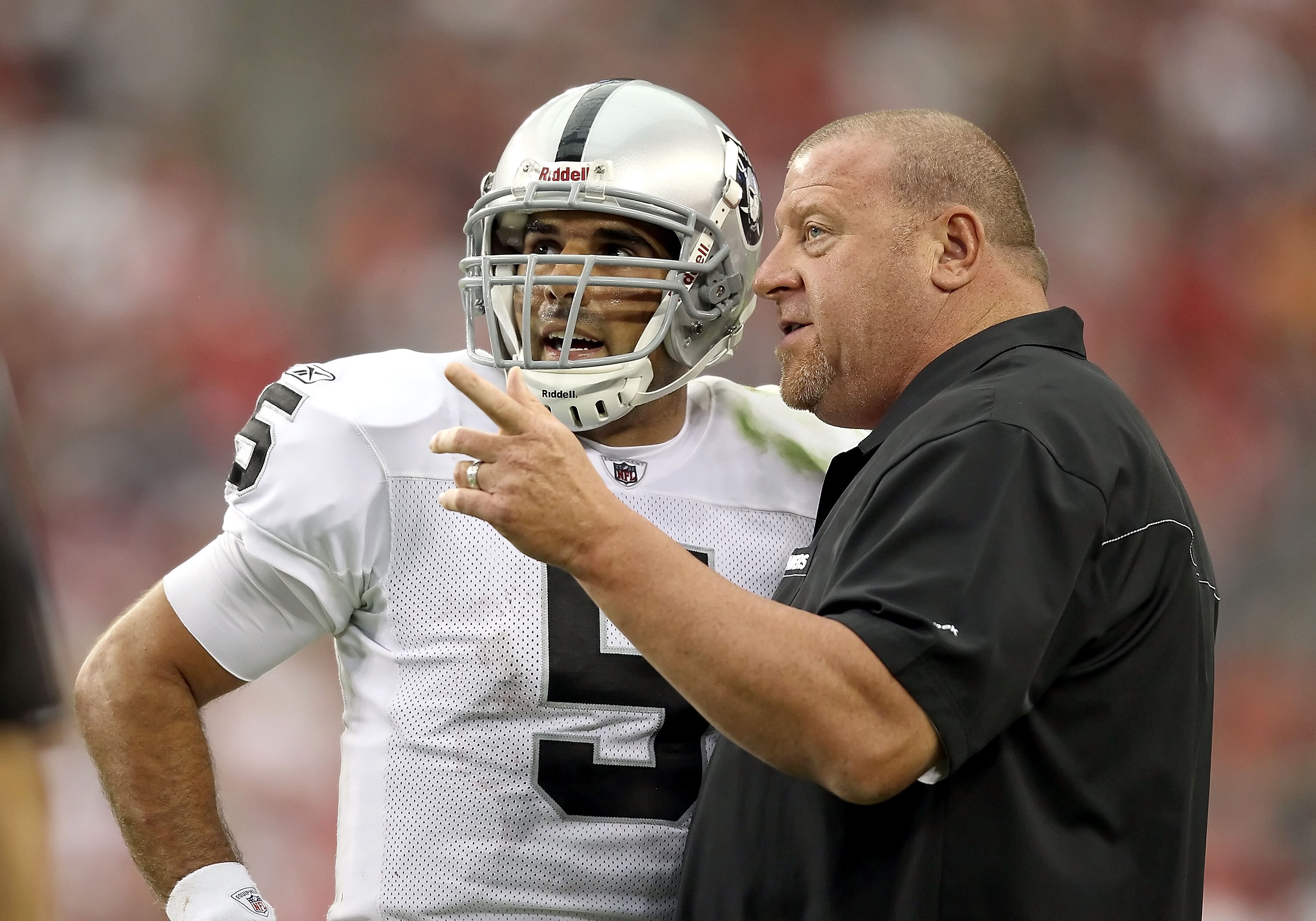 GLENDALE, AZ - SEPTEMBER 26:  Head coach Tom Cable of the Oakland Raiders talks with quarterback Bruce Gradkowski #5 during the fourth quarter of the NFL game against the Arizona Cardinals at the University of Phoenix Stadium on September 26, 2010 in Glen