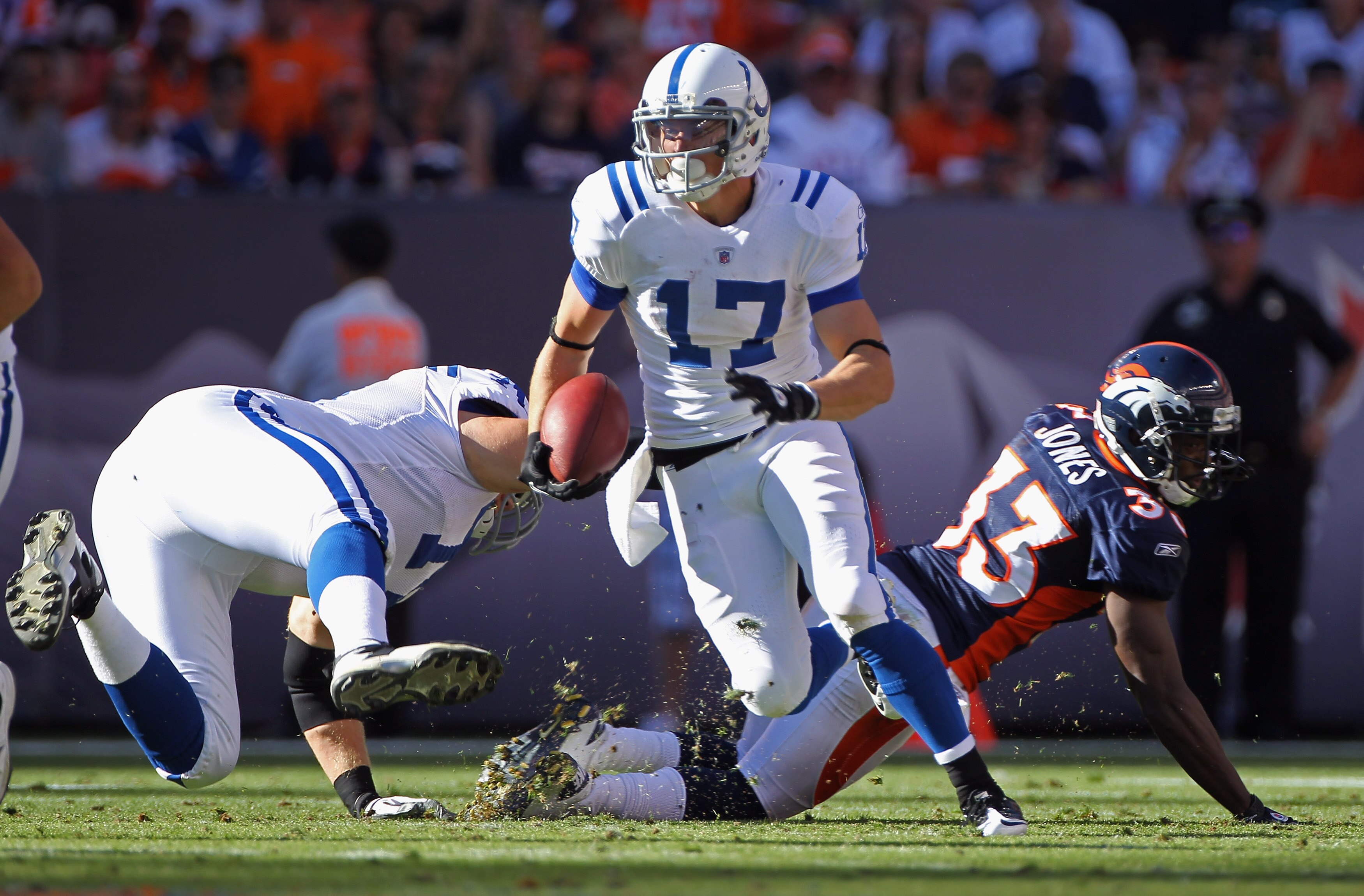 DENVER - SEPTEMBER 26:  Wide receiver Austin Collie #17 of the Indianapolis Colts makes a reception and picks up a first down as as Ryan Diem #71 of the Colts blocks Nate Jones #33 of the Denver Broncos at INVESCO Field at Mile High on September 26, 2010