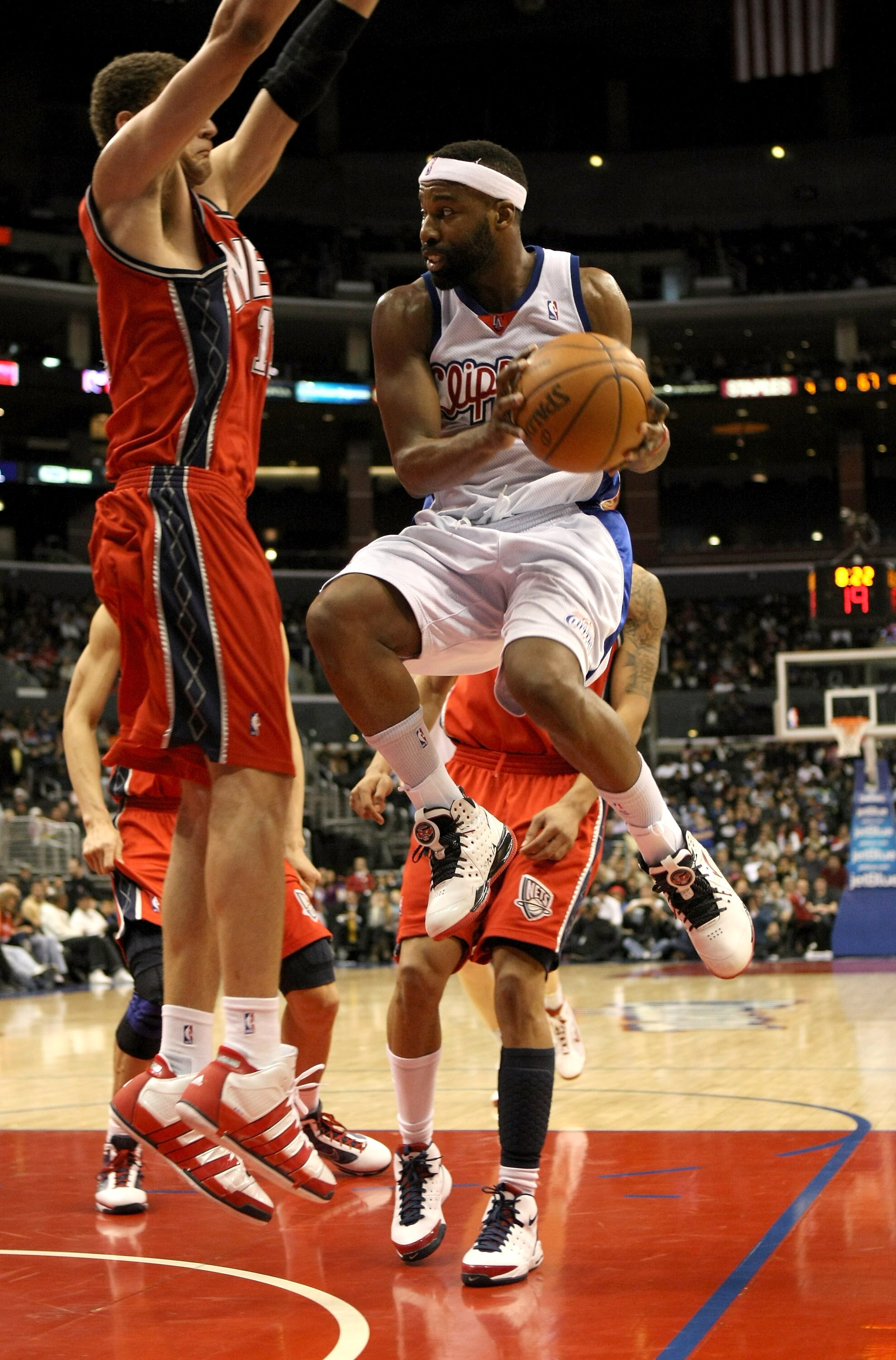 LOS ANGELES, CA - JANUARY 18:  Baron Davis #1 of the Los Angeles Clippers looks to pass as he jumps through the lane against Brook Lopez #11 of the New Jersey Nets on January 18, 2010 at Staples Center in Los Angeles, California. The Clippers won 106-95.