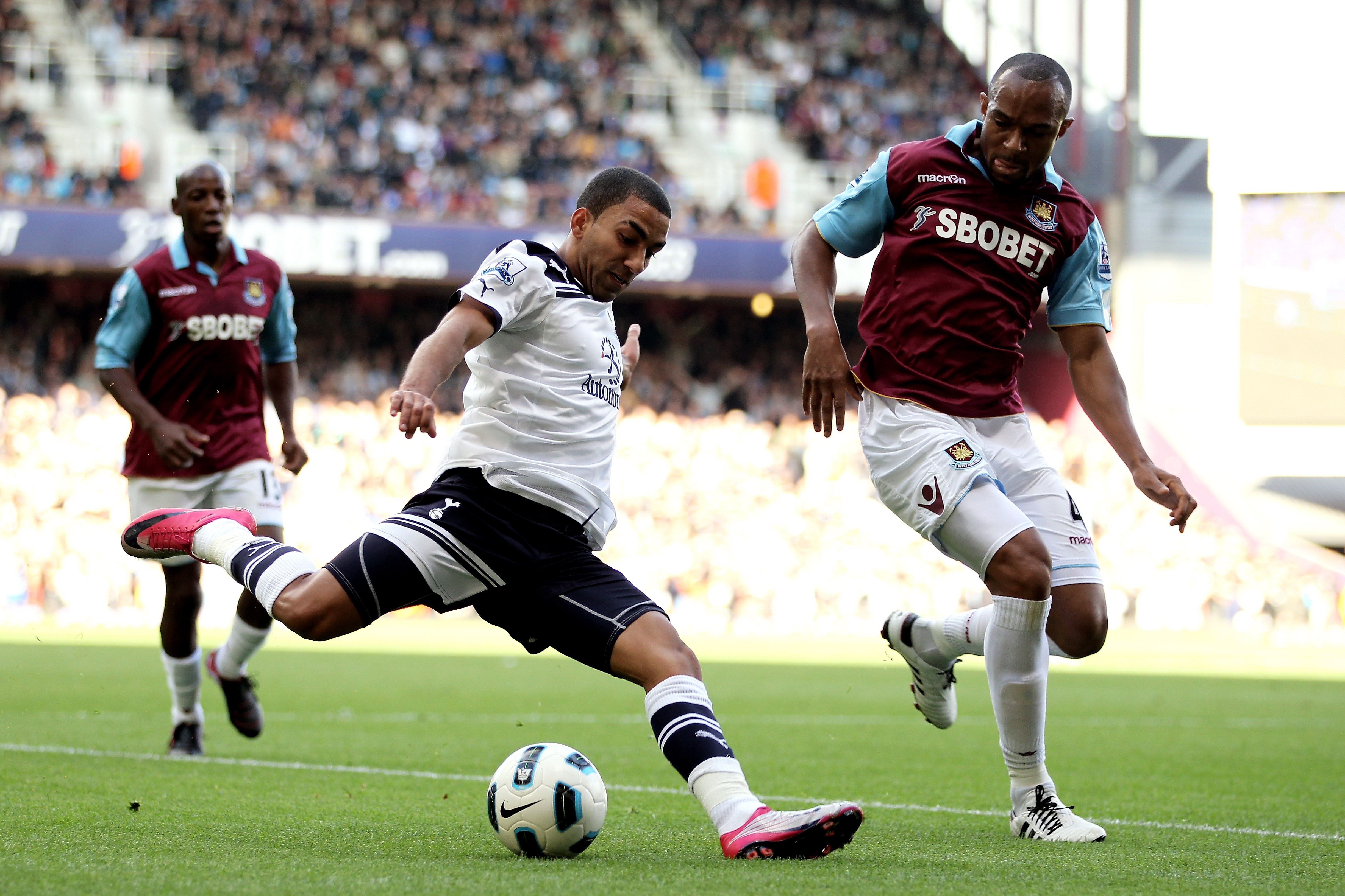 LONDON, ENGLAND - SEPTEMBER 25:  Aaron Lennon of Spurs crosses the ball as Danny Gabbidon of West Ham closes in during the Barclays Premier League match between West Ham United and Tottenham Hotspur at the Boleyn Ground on September 25, 2010 in London, En