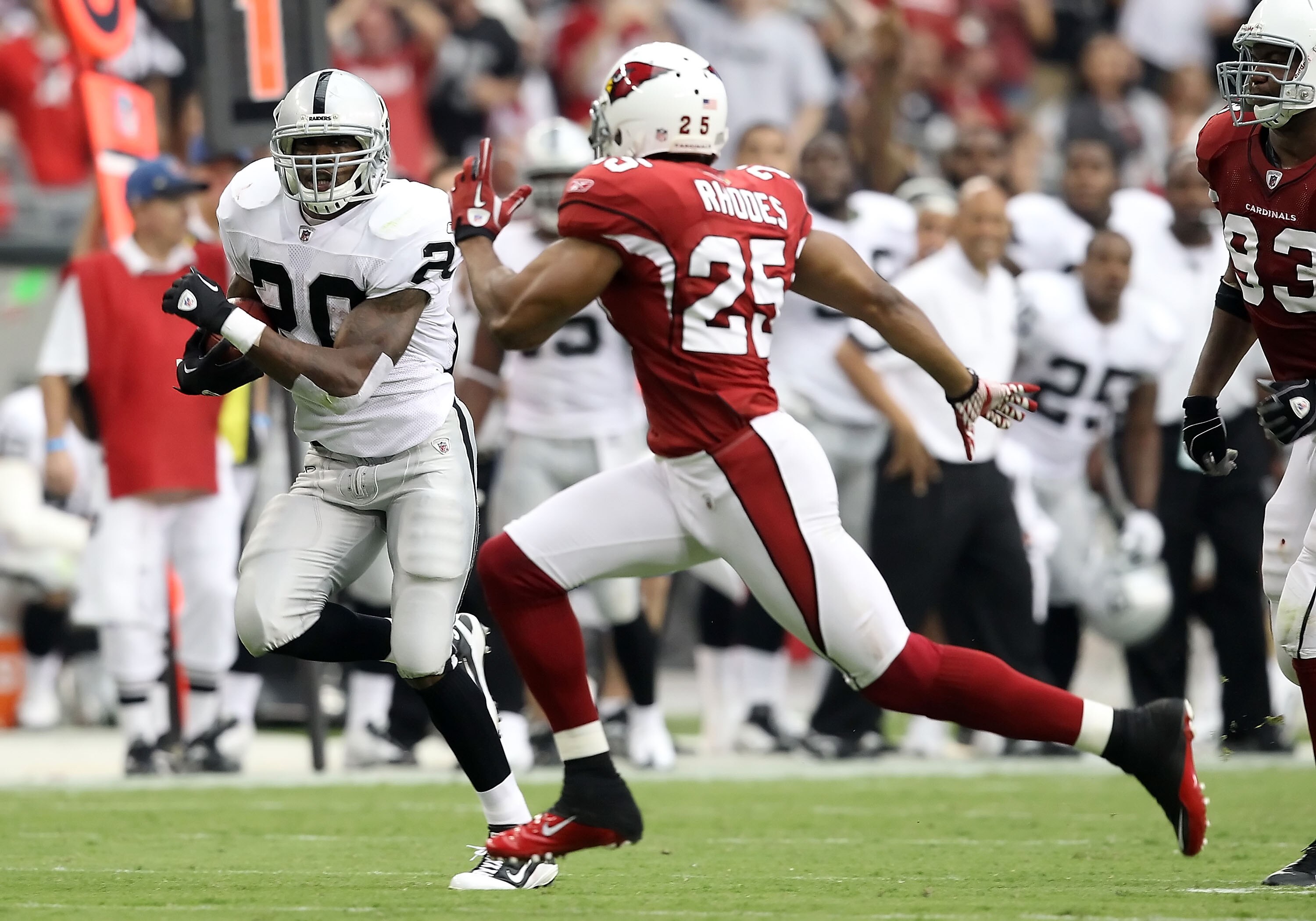GLENDALE, AZ - SEPTEMBER 26:  Runningback Darren McFadden #20 of the Oakland Raiders rushes the football past Kerry Rhodes #25 of the Arizona Cardinals during the thrid quarter of the NFL game at the University of Phoenix Stadium on September 26, 2010 in