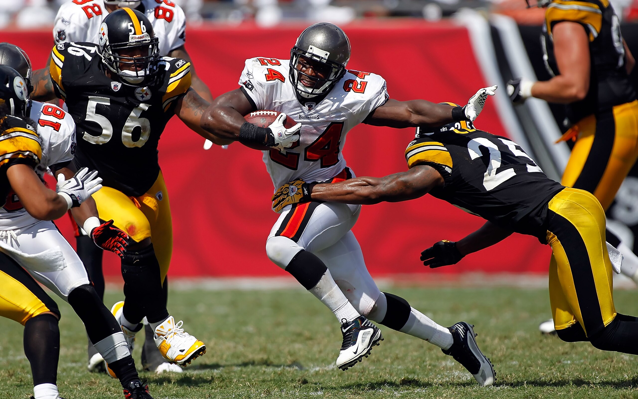 TAMPA, FL - SEPTEMBER 26:  Running back Carnell Williams #24 of the Tampa Bay Buccaneers runs through the tackle of safety Ryan Clark #25 of the Pittsburgh Steelers during the game at Raymond James Stadium on September 26, 2010 in Tampa, Florida. The unde