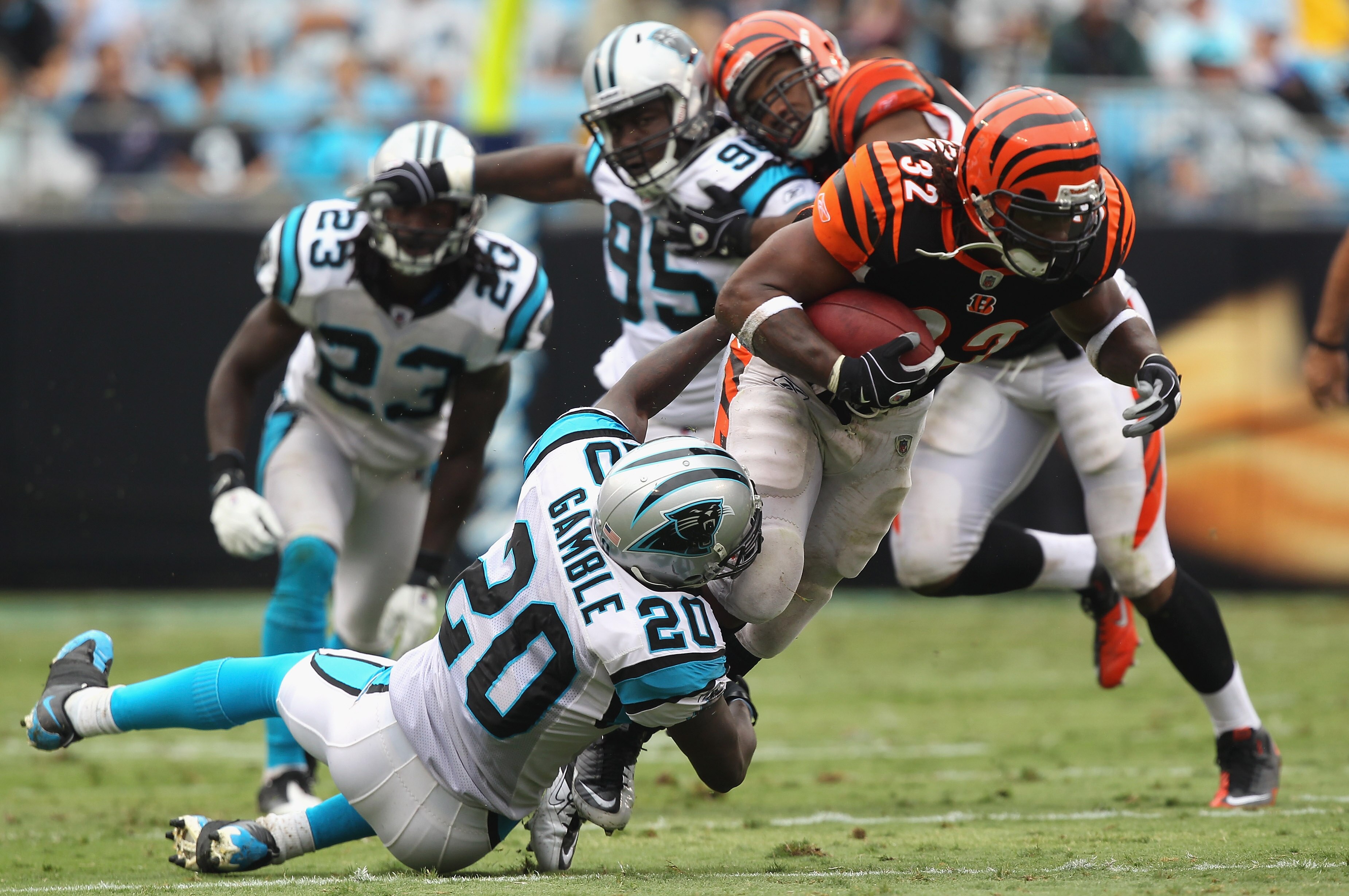 CHARLOTTE, NC - SEPTEMBER 26:  Cedric Benson #32 of the Cincinnati Bengals is tackled by Chris Gamble #20 of the Carolina Panthers during their game at Bank of America Stadium on September 26, 2010 in Charlotte, North Carolina.  (Photo by Streeter Lecka/G