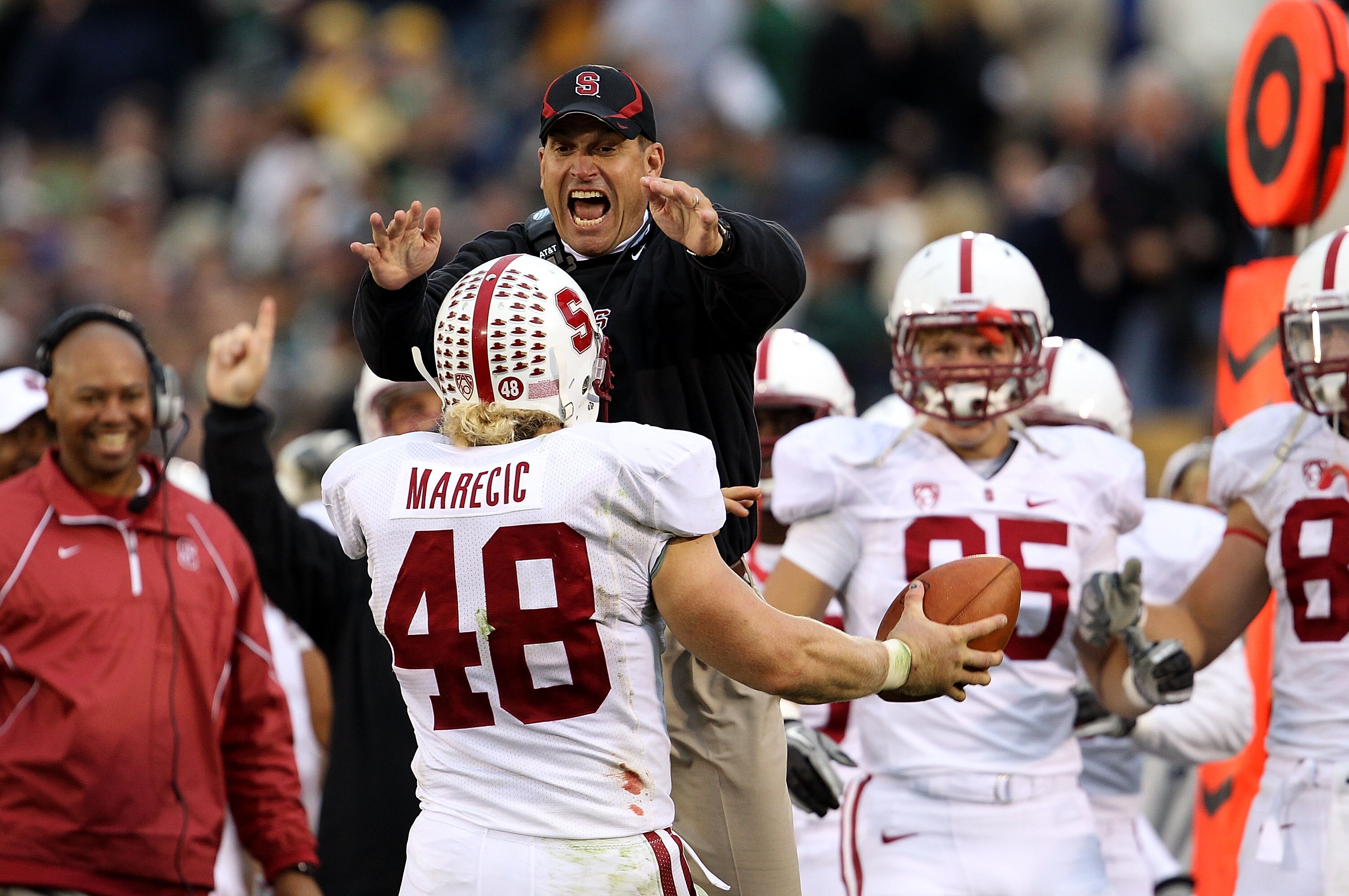 SOUTH BEND, IN - SEPTEMBER 25: Head coach Jim Harbaugh of the Stanford Cardinal jumps to greet Owen Marecic #48 after Marecic intercepted a pass for a touchdown against the Notre Dame Fighting Irish at Notre Dame Stadium on September 25, 2010 in South Ben