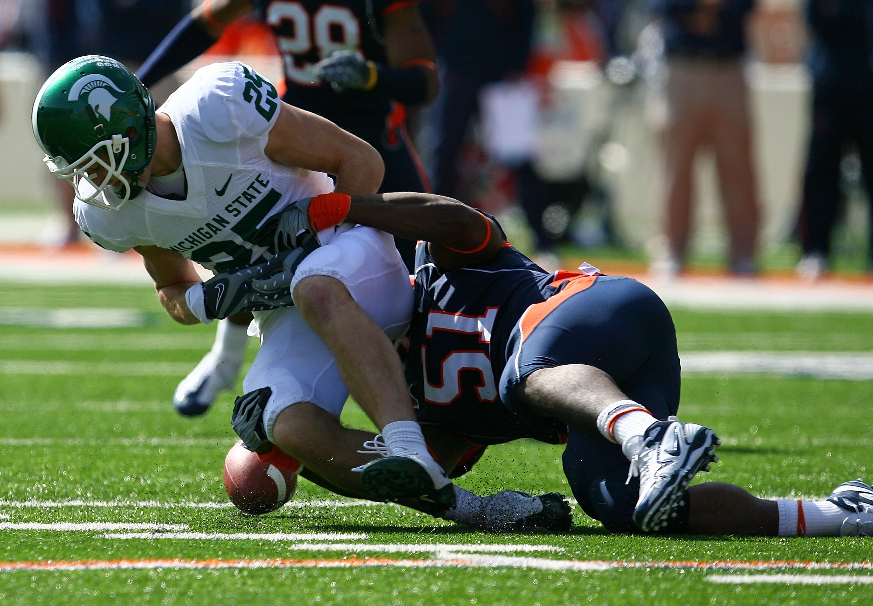 CHAMPAIGN, IL - OCTOBER 10: Evan Frierson #51 of the Illinois Fighting Illini tackles Blair White #25 of the Michigan State Spartans causing an apparent fumble that was ruled down on October 10, 2009 at Memorial Stadium at the University of Illinois in Ch