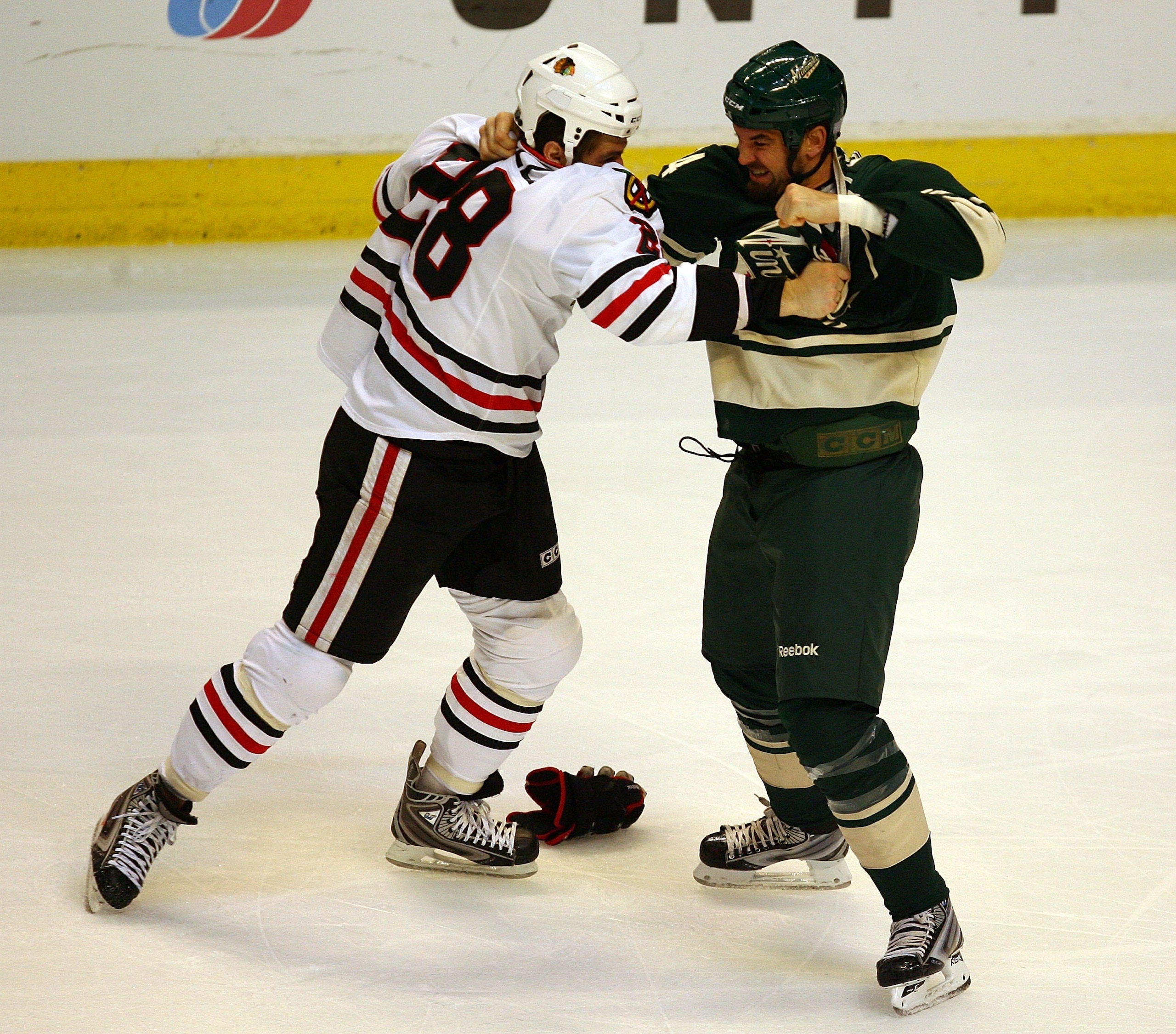 CHICAGO - OCTOBER 26: Jake Dowell #28 of the Chicago Blackhawks fights with Shane Hnidy #34 of the Minnesota Wild at the United Center on October 26, 2009 in Chicago, Illinois. The Blackhawks defeated the Wild 3-1. (Photo by Jonathan Daniel/Getty Images)
