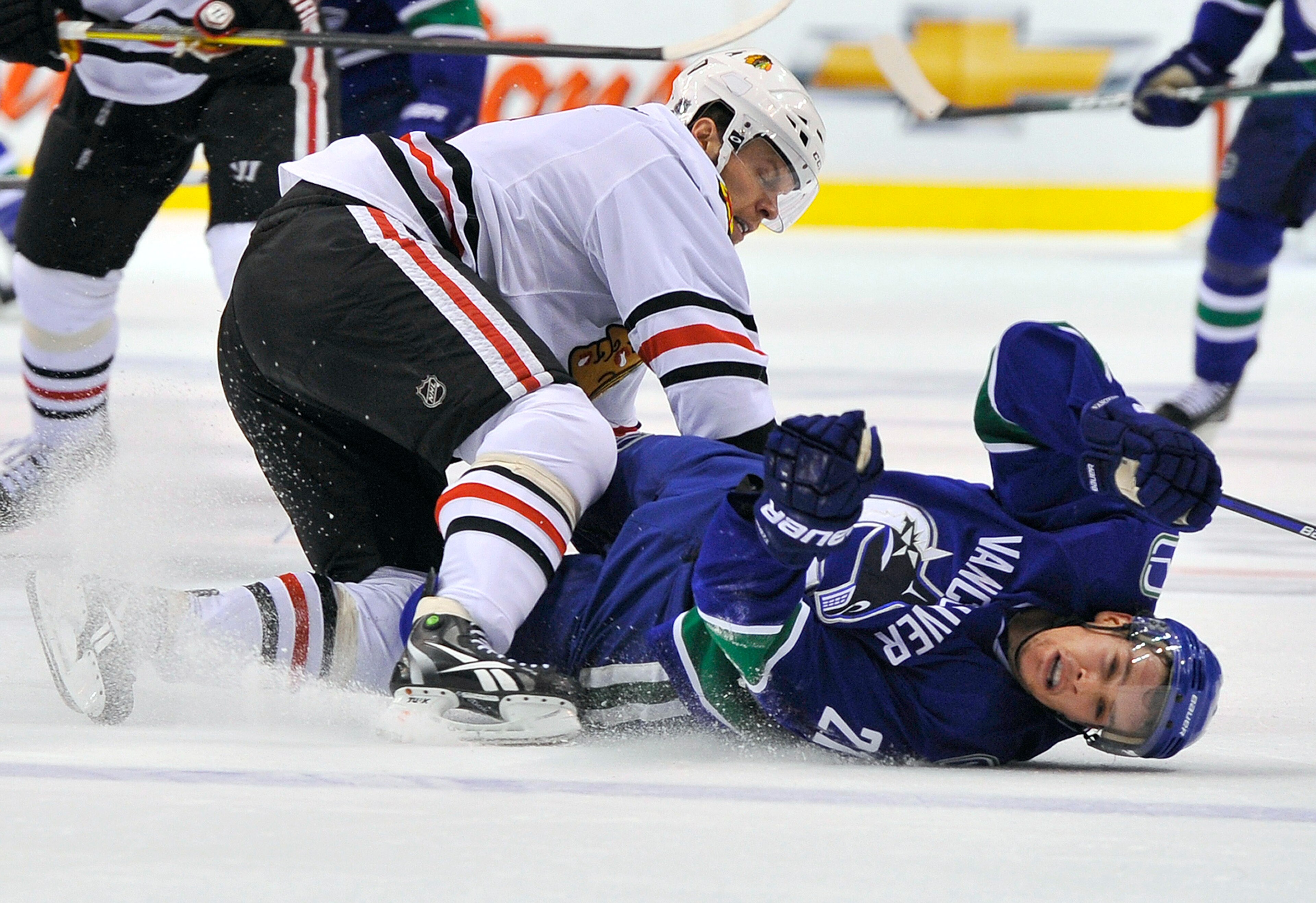 VANCOUVER, CANADA - MAY 5:  Mason Raymond #21 of the Vancouver Canucks lies on the ice after getting hit by Jordan Hendry #6 of the Chicago Blackhawks during the third period in Game Three of the Western Conference Semifinals during the 2010 NHL Stanley C