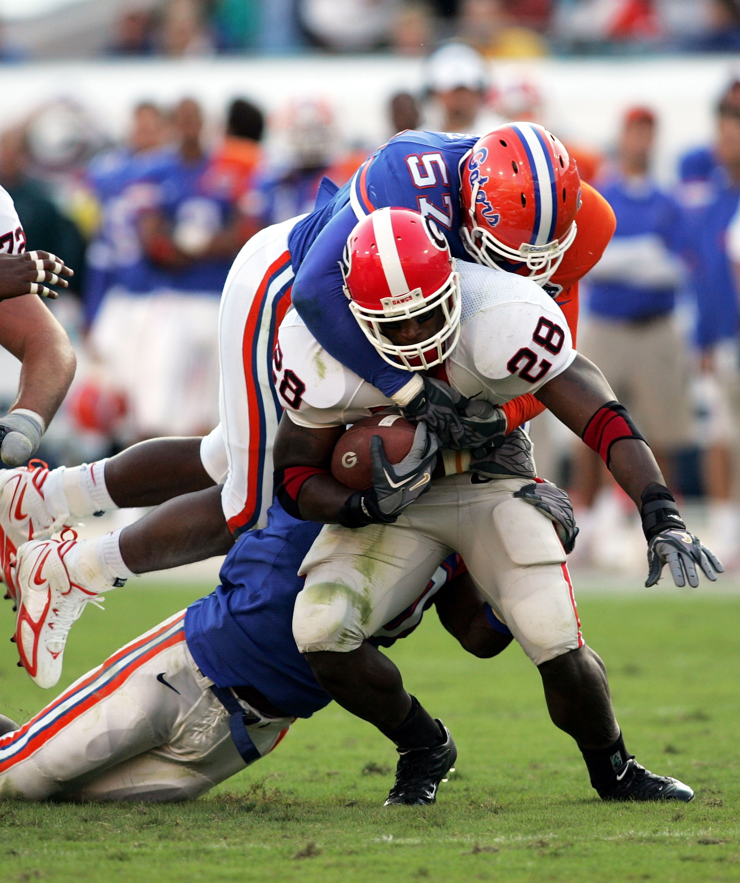 JACKSONVILLE, FL - OCTOBER 29:  Running back Danny Ware #28 of the Georgia Bulldogs is brought down by linebacker Jeremy Mincey #57 of the Florida Gators at Alltel Stadium on October 29, 2005 in Jacksonville, Florida. Florida defeated Georgia 14-10.  (Pho