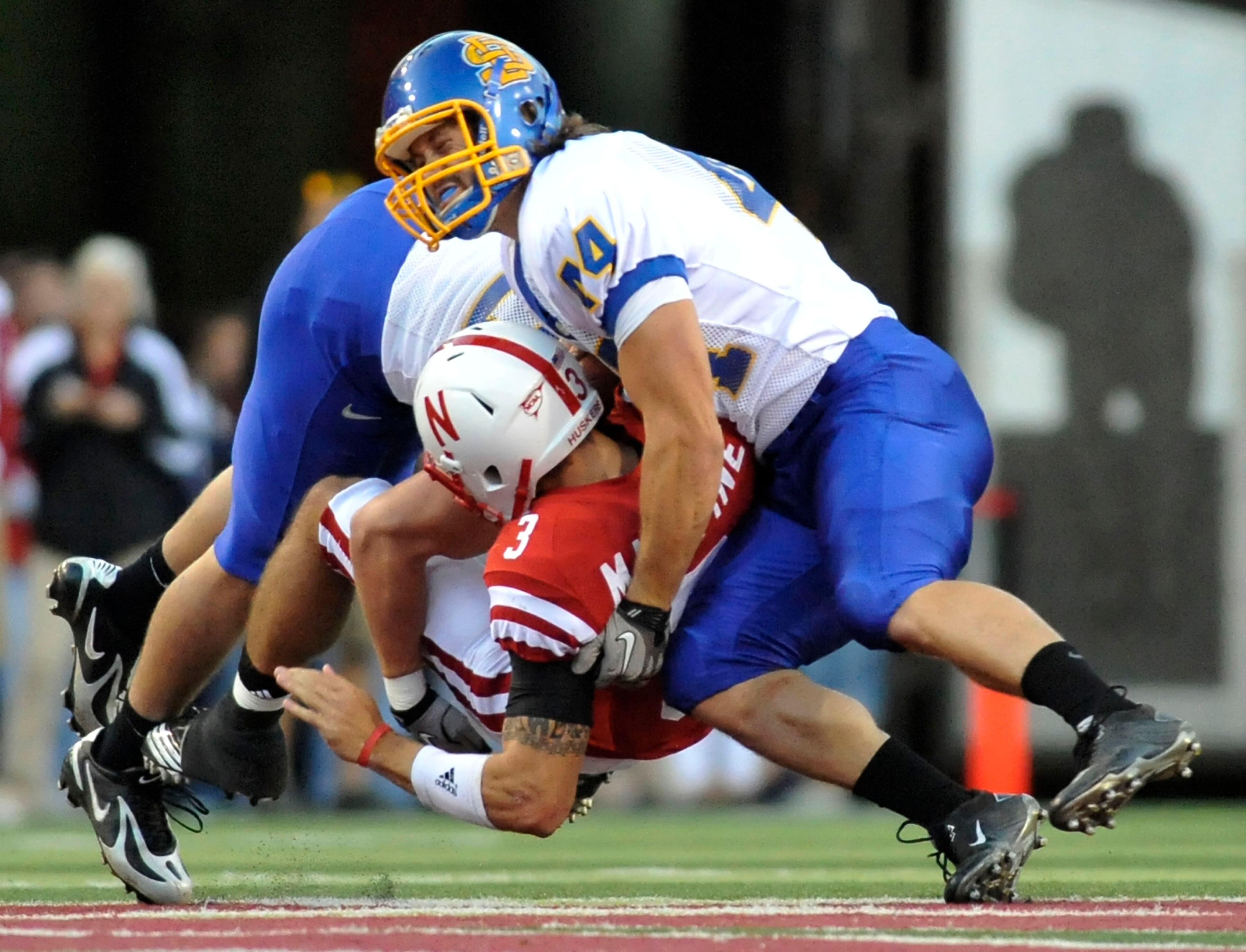 LINCOLN, NE - SEPTEMBER 25: Quarterback Taylor Martinez #3 of the Nebraska Cornhuskers get crunched by linebacker Ross Shafrath #44 of the South Dakota State Jackrabbits and a teammate during first half action of their game at Memorial Stadium on Septembe