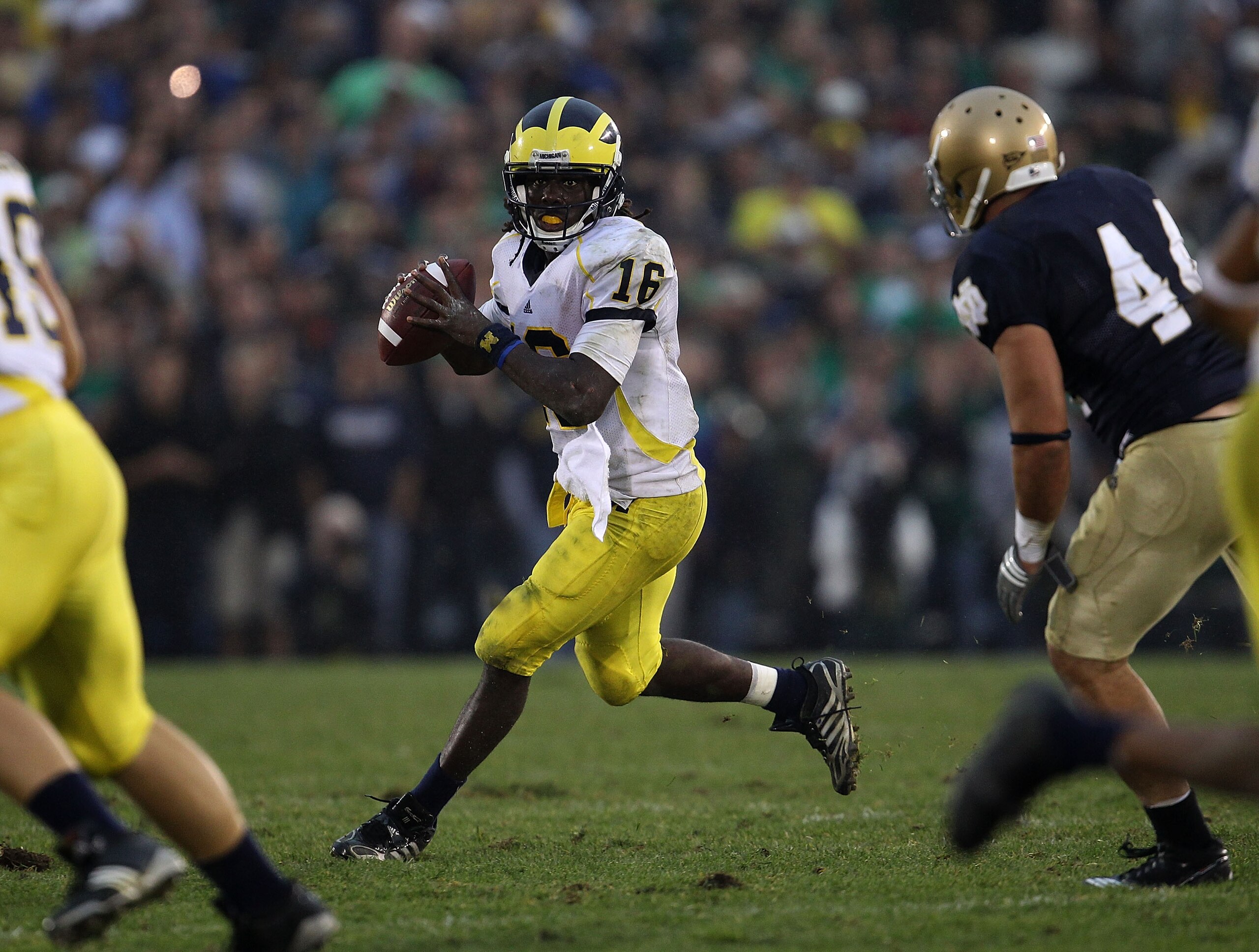 SOUTH BEND, IN - SEPTEMBER 11: Denard Robinson #16 of the Michigan Wolverines looks for a receiver under pressure from Carlo Calabrese #44 of the Notre Dame Fighting Irish at Notre Dame Stadium on September 11, 2010 in South Bend, Indiana. Michigan defeat