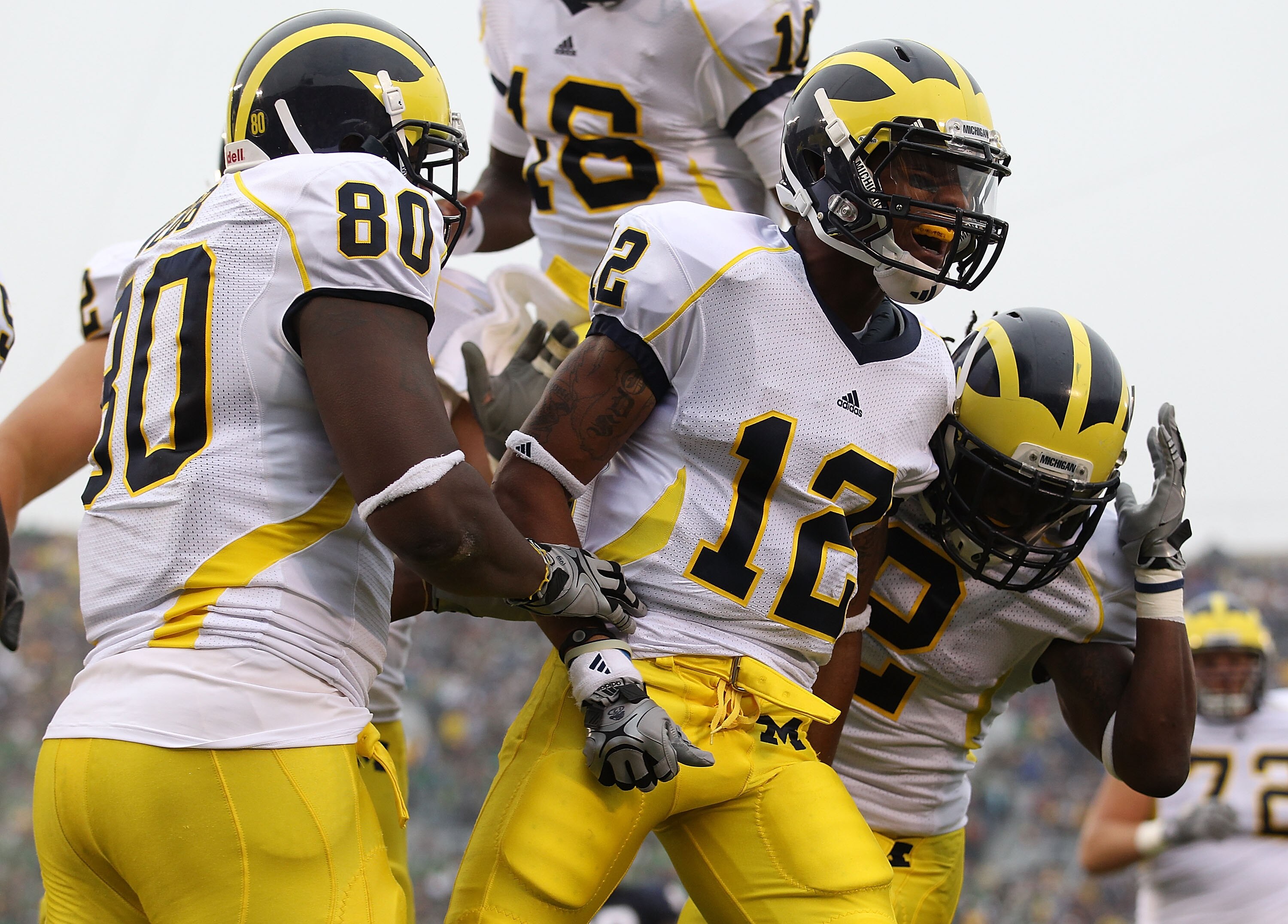 SOUTH BEND, IN - SEPTEMBER 11: Roy Roundtree #12 of the Michigan Wolverines celebrates a touchdown with teammates Martell Webb #80 and Vincent Smith #2 against the Notre Dame Fighting Irish at Notre Dame Stadium on September 11, 2010 in South Bend, Indian