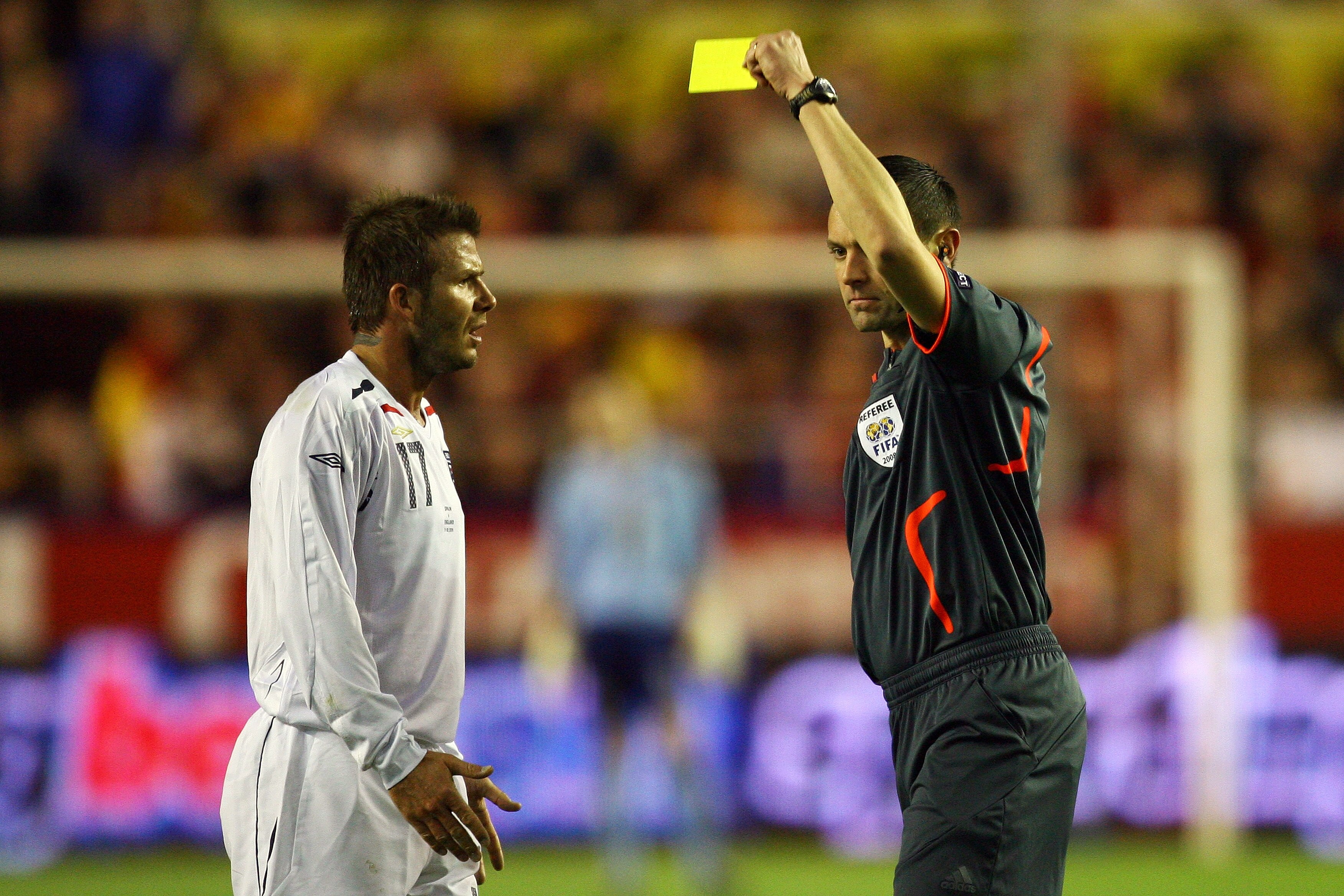 SEVILLE, SPAIN - FEBRUARY 11:  David Beckham of England is shown the yellow card by Stephane Lannoy of France during the International Friendly between Spain and England at the Ramon Sanchez Pizjuan Stadium on February 11, 2009 in Seville, Spain.  (Photo