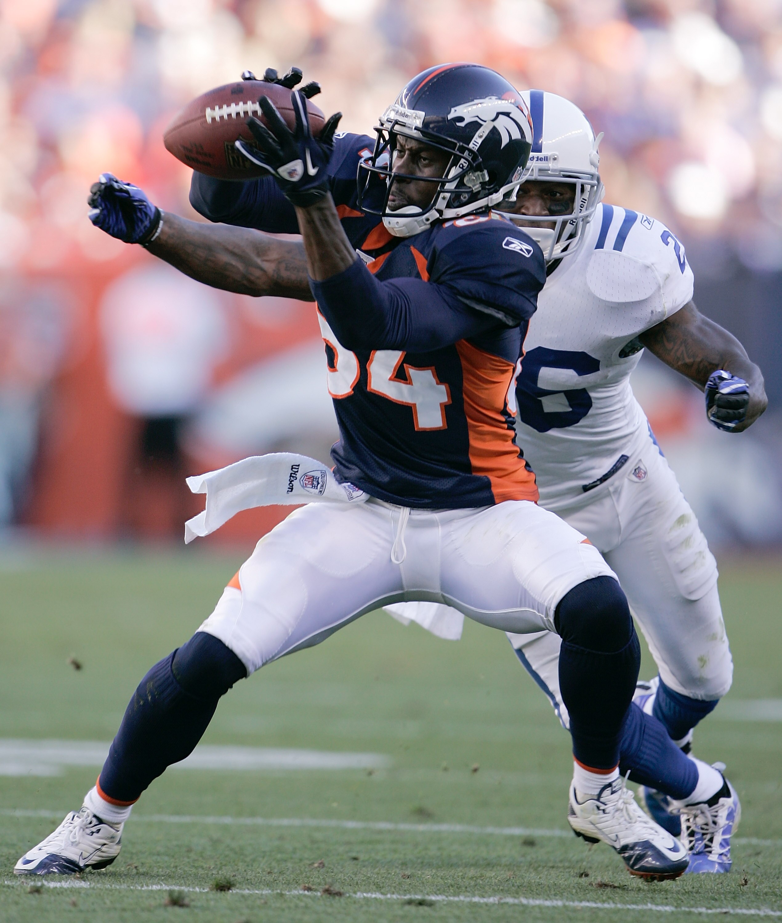 DENVER - SEPTEMBER 26:  Wide receiver Brandon Lloyd #84 of the Denver Broncos makes a catch in front of cornerback Kelvin Hayden #26 of the Indianapolis Colts during NFL action at INVESCO Field at Mile High on September 26, 2010 in Denver, Colorado. The C