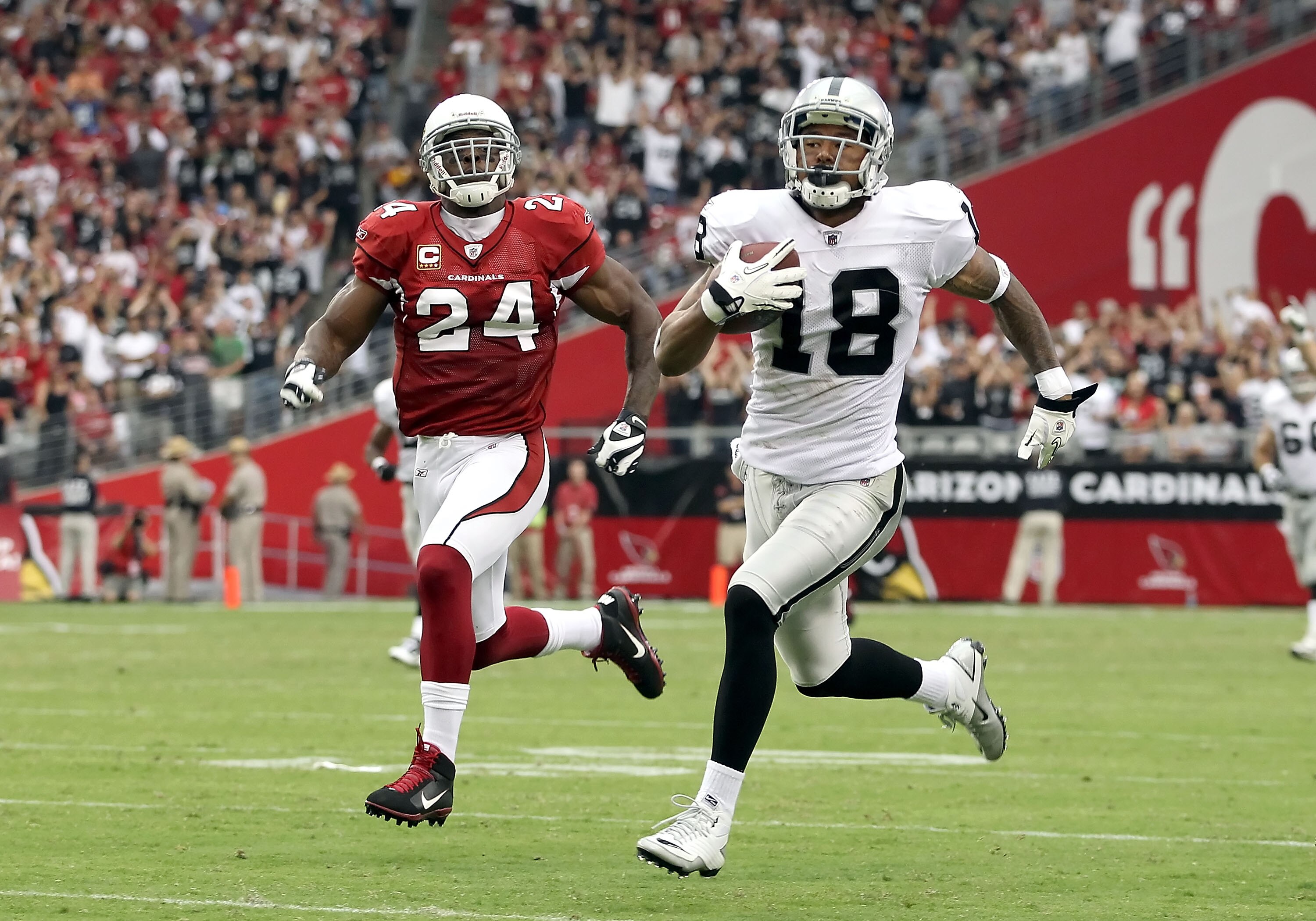 GLENDALE, AZ - SEPTEMBER 26:  Wide receiver Louis Murphy #18 of the Oakland Raiders runs with the football after a 13 yard reception past Adrian Wilson #24 of the Arizona Cardinals during the thrid quarter of the NFL game at the University of Phoenix Stad
