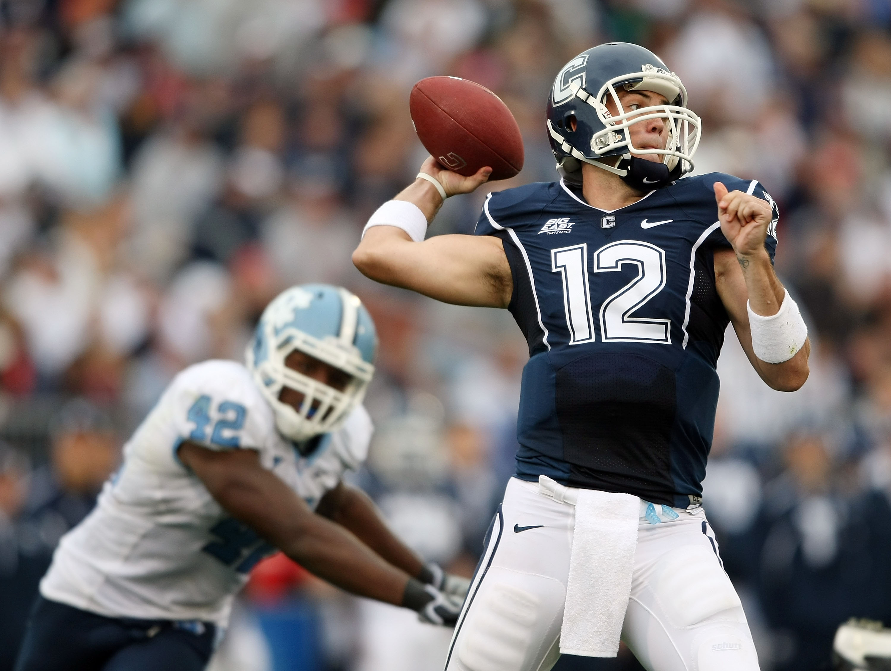 EAST HARTFORD, CT - SEPTEMBER 12:  Cody Endres #12 of the Connecticut Huskies passes under pressure from Robert Quinn #42 of the North Carolinia Tar Heels pressures on September 12, 2009 at Rentschler Field in East Hartford, Connecticut. The Tar Heels def