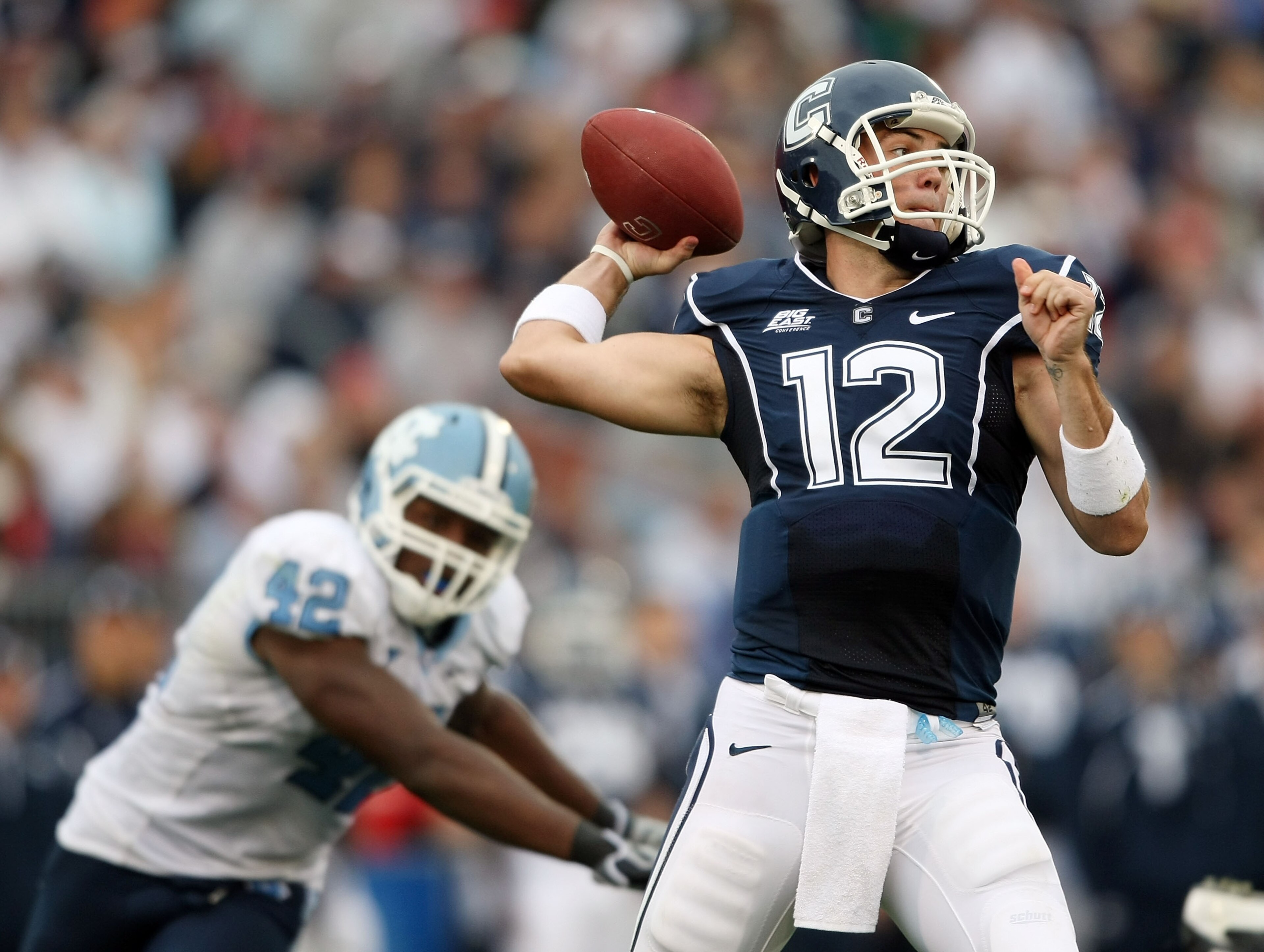 EAST HARTFORD, CT - SEPTEMBER 12:  Cody Endres #12 of the Connecticut Huskies passes under pressure from Robert Quinn #42 of the North Carolinia Tar Heels pressures on September 12, 2009 at Rentschler Field in East Hartford, Connecticut. The Tar Heels def