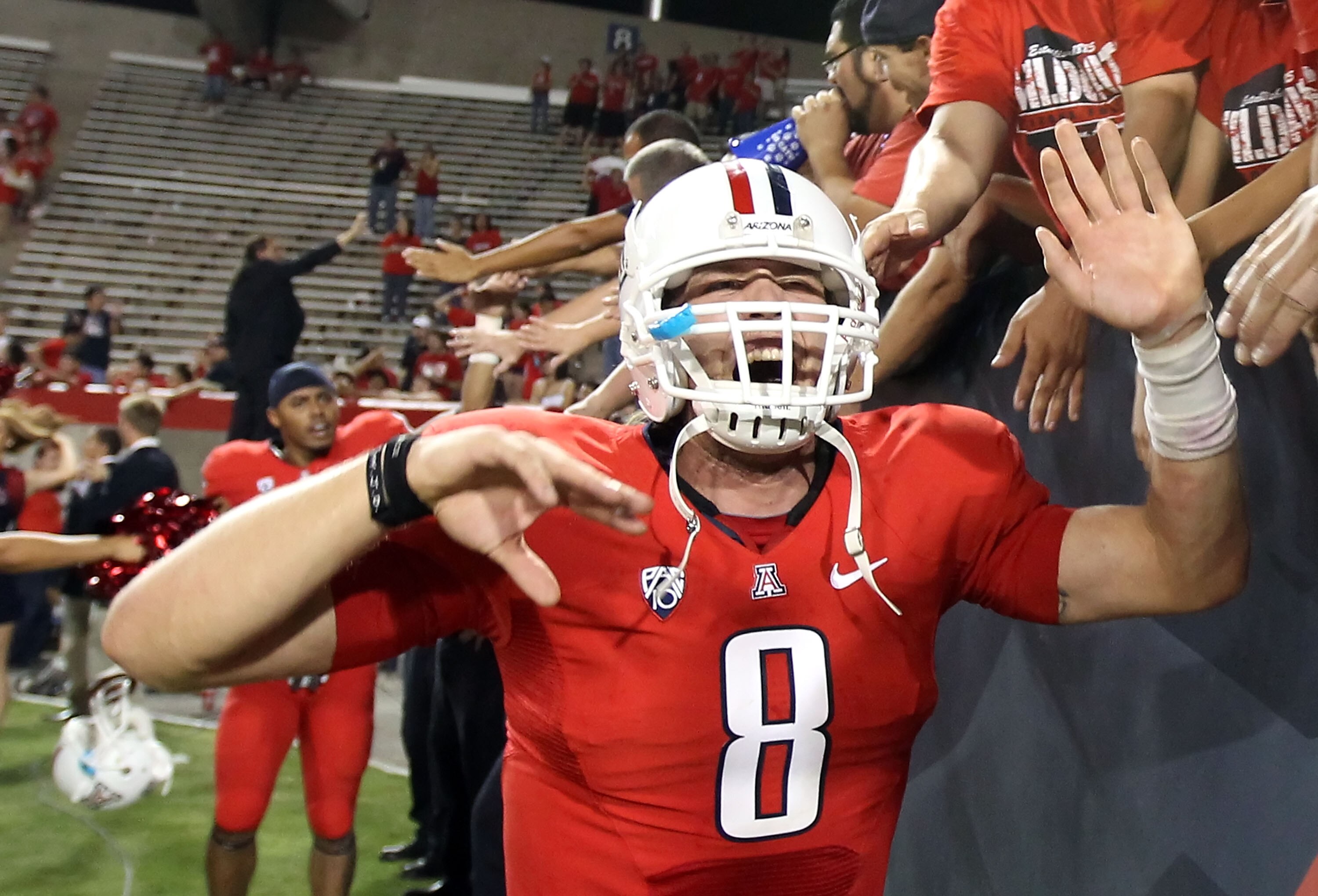 TUCSON, AZ - SEPTEMBER 25:  Quarterback Nick Foles #8 of the Arizona Wildcats celebrates with fans after defeating the California Golden Bears in the college football game at Arizona Stadium on September 25, 2010 in Tucson, Arizona.  The Wildcats defeated